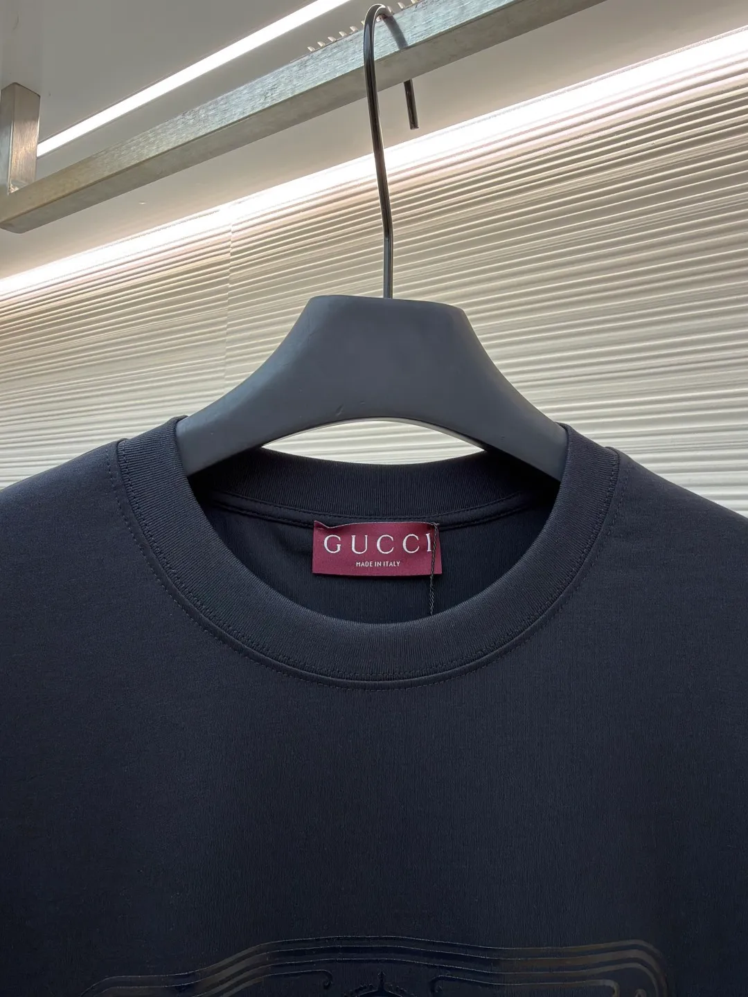 Gucci Buddha City printed round neck short sleeves ●Original version: purchased and developed by 5039 ●Item number: 1682281-A00 ●Fabric: soft knitted cotton fabric ●Technology: Glue printing production ●Color: black ●Version: fitted version ●Weight: about 235 grams ●Size: XS-S-M-L ●Description: This product is made of 60-count single-yarn double-sided knitted cotton with a weight of 170g/㎡; the neckline and other parts are matched with 32-count double-yarn ribbing. The high weight ensures a stable collar shape. 60 counts is an extremely high count, which means the yarn is extremely fine, which directly gives the fabric an extraordinary delicate, silky and soft touch. The front and back sides of the double-sided fabric have the same texture, which is uniform, thin and elastic. The weight of 170g is lightweight, ensuring the T-shirt is extremely light, breathable and drapey. It is almost invisible when worn and is very suitable for early spring. The color of the fabric is soft and high-end, which further enhances the exquisite texture of the fabric. The direct expression of the printing collection elements uses the environmentally friendly elastic thick plate bright glue printing process to place such a three-dimensional, bright, and highly present slogan printing on the simple sweater. This is a high-end special printing technology. Thick plate means that the slurry is accumulated thickly, which can form an obvious three-dimensional effect; after the bright slurry is cured, the surface will show a high-gloss glossy effect; the slurry itself is elastic and can stretch with the fabric. The special environmentally friendly elastic bright slurry is transferred through thick coating on the screen and then solidified at high temperature. Create a brand slogan pattern with significant 3D raised texture, mirror-like luster, and strong stretch resistance. To the touch, the pattern area has obvious stiff bulges and a smooth lacquered surface, which forms a strong contrast with the extremely soft fabric base and has a strong visual impact. The overall wiring is straight and delicate, the fabric is comfortable and soft, and the color is consistent without color difference. It can be matched with the same style to create a fashionable look and control various occasions. Customized accessories, complete with three standards, same style for men and women!