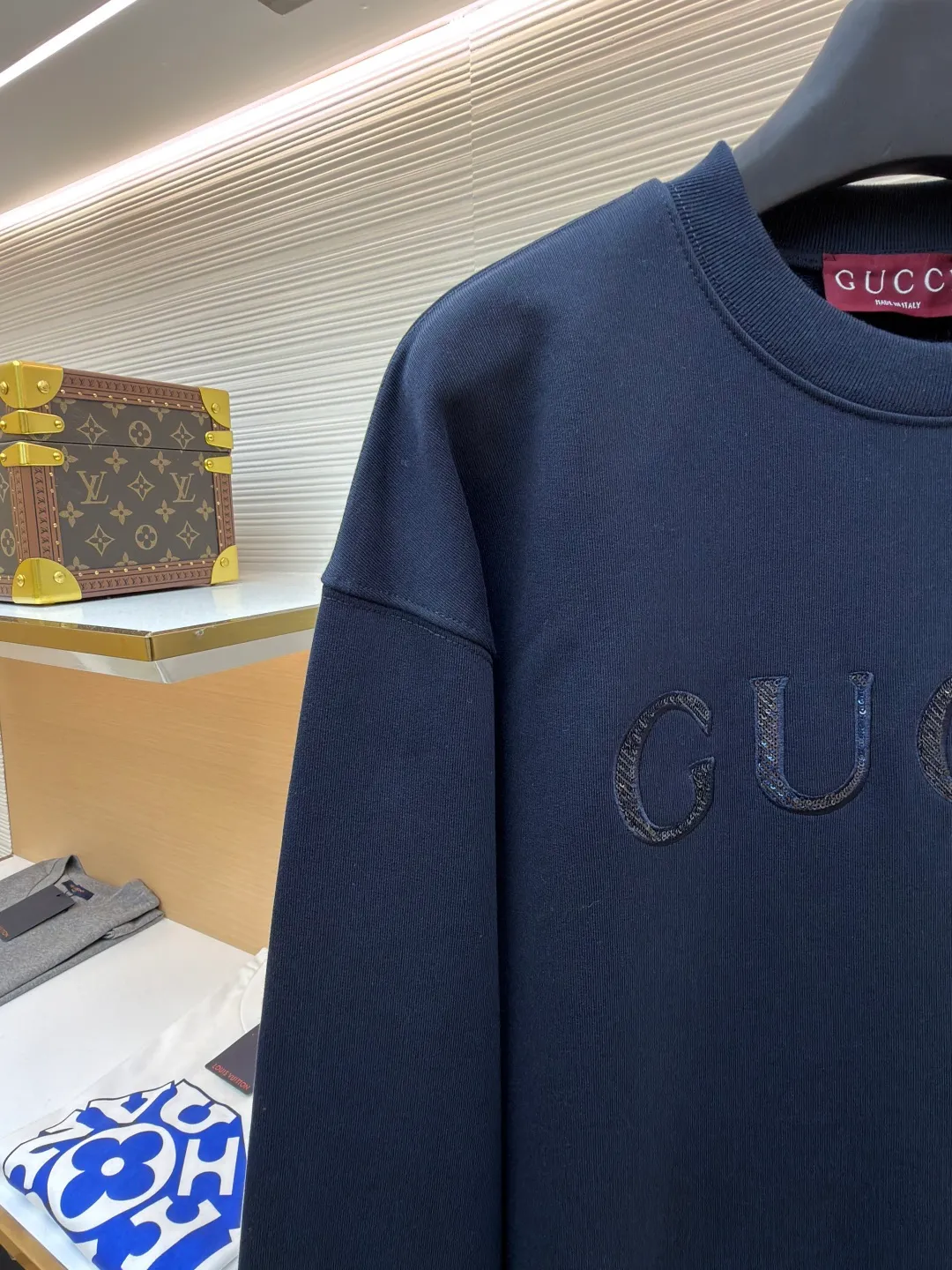 Gucci sequin round neck sweatshirt ●Original version: purchased and developed by 12060 ●Item number: 1682071-A65 ●Fabric: knitted cotton sweatshirt fabric ●Technology: double dyeing ●Color: navy blue ●Version: fitted version ●Weight: about 630 grams ●Size: XS-S-M-L ●Description: It adopts a composite structure of 26-count double yarn top layer + 10-count yarn fish scale terry bottom, with a weight of 380g/㎡; it is paired with 21-count 1x1 ribs, with a weight of 470g, and is used for the collar, cuffs and hem, ensuring the ultimate thickness, stiffness and deformation resistance of these key parts. The 26-count double yarn forms a smooth, delicate and strong outer surface of the fabric, ensuring good appearance and color fastness; the 10-count fish scale terry bottom is woven to form a unique fish scale-shaped coil. After being raised or fleeced, a layer of extremely rich, dense and unique texture is formed on the inside of the fabric. The sweatshirt combines a crisp and skeletal feel on the outside with an extremely warm and soft feel on the inside. A composite embroidery process that combines tiny sequins with embroidery thread. While the pattern is being embroidered on a computer embroidery machine, pieces of sequins are accurately positioned on the pattern through special devices or pre-arrangements, and their edges are fixed with embroidery thread. Navy blue, as the main color, is a deep, calm and classic color. It provides an excellent dark background for the sequin embroidery, making the luster of the sequins more prominent. The matte, slightly velvety texture of the fabric and the smooth, shiny sequins create a dual tactile and visual contrast. Instantly enhance the gorgeousness and visual impact of a single product, making it highly recognizable. The overall wiring is straight and delicate, the fabric is comfortable and soft, and the color is consistent without color difference. It can be matched with the same style to create a fashionable look and control various occasions. Customized accessories, complete with three standards, same style for men and women!