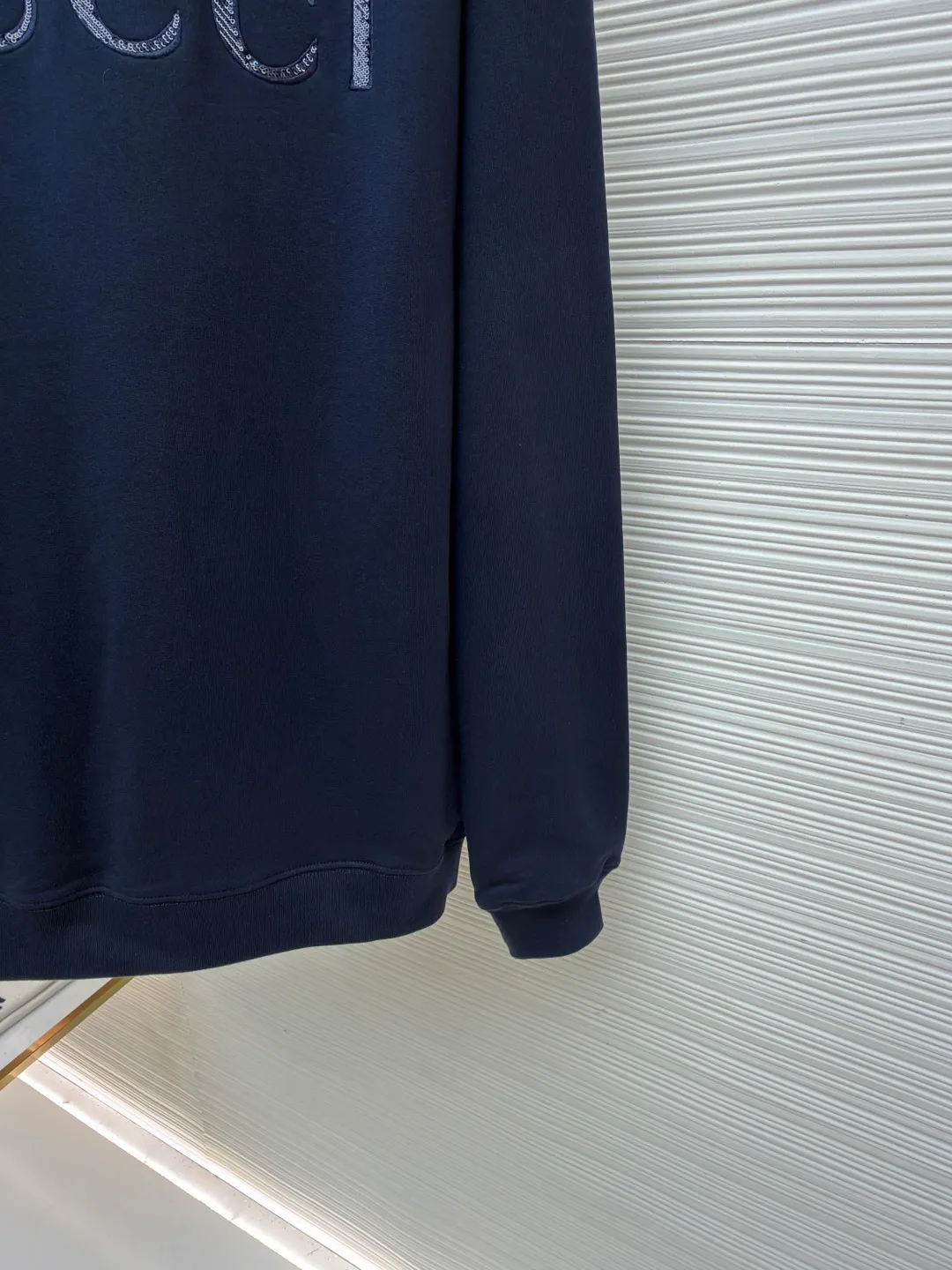 Gucci sequin round neck sweatshirt ●Original version: purchased and developed by 12060 ●Item number: 1682071-A65 ●Fabric: knitted cotton sweatshirt fabric ●Technology: double dyeing ●Color: navy blue ●Version: fitted version ●Weight: about 630 grams ●Size: XS-S-M-L ●Description: It adopts a composite structure of 26-count double yarn top layer + 10-count yarn fish scale terry bottom, with a weight of 380g/㎡; it is paired with 21-count 1x1 ribs, with a weight of 470g, and is used for the collar, cuffs and hem, ensuring the ultimate thickness, stiffness and deformation resistance of these key parts. The 26-count double yarn forms a smooth, delicate and strong outer surface of the fabric, ensuring good appearance and color fastness; the 10-count fish scale terry bottom is woven to form a unique fish scale-shaped coil. After being raised or fleeced, a layer of extremely rich, dense and unique texture is formed on the inside of the fabric. The sweatshirt combines a crisp and skeletal feel on the outside with an extremely warm and soft feel on the inside. A composite embroidery process that combines tiny sequins with embroidery thread. While the pattern is being embroidered on a computer embroidery machine, pieces of sequins are accurately positioned on the pattern through special devices or pre-arrangements, and their edges are fixed with embroidery thread. Navy blue, as the main color, is a deep, calm and classic color. It provides an excellent dark background for the sequin embroidery, making the luster of the sequins more prominent. The matte, slightly velvety texture of the fabric and the smooth, shiny sequins create a dual tactile and visual contrast. Instantly enhance the gorgeousness and visual impact of a single product, making it highly recognizable. The overall wiring is straight and delicate, the fabric is comfortable and soft, and the color is consistent without color difference. It can be matched with the same style to create a fashionable look and control various occasions. Customized accessories, complete with three standards, same style for men and women!
