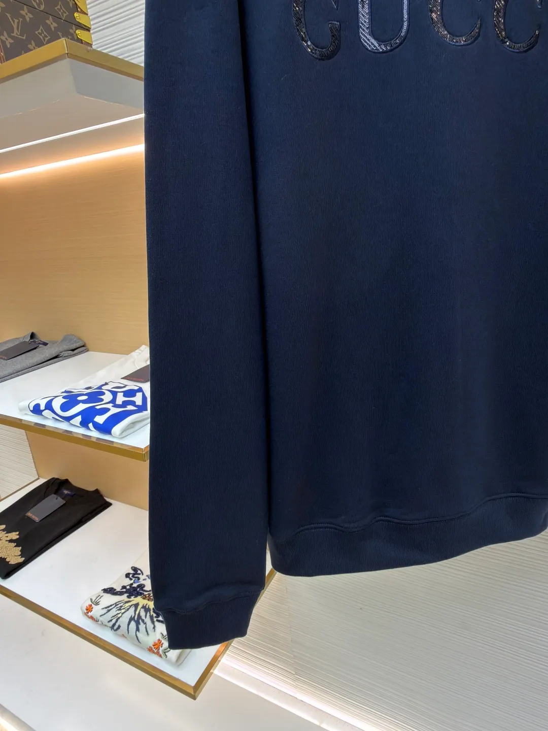 Gucci sequin round neck sweatshirt ●Original version: purchased and developed by 12060 ●Item number: 1682071-A65 ●Fabric: knitted cotton sweatshirt fabric ●Technology: double dyeing ●Color: navy blue ●Version: fitted version ●Weight: about 630 grams ●Size: XS-S-M-L ●Description: It adopts a composite structure of 26-count double yarn top layer + 10-count yarn fish scale terry bottom, with a weight of 380g/㎡; it is paired with 21-count 1x1 ribs, with a weight of 470g, and is used for the collar, cuffs and hem, ensuring the ultimate thickness, stiffness and deformation resistance of these key parts. The 26-count double yarn forms a smooth, delicate and strong outer surface of the fabric, ensuring good appearance and color fastness; the 10-count fish scale terry bottom is woven to form a unique fish scale-shaped coil. After being raised or fleeced, a layer of extremely rich, dense and unique texture is formed on the inside of the fabric. The sweatshirt combines a crisp and skeletal feel on the outside with an extremely warm and soft feel on the inside. A composite embroidery process that combines tiny sequins with embroidery thread. While the pattern is being embroidered on a computer embroidery machine, pieces of sequins are accurately positioned on the pattern through special devices or pre-arrangements, and their edges are fixed with embroidery thread. Navy blue, as the main color, is a deep, calm and classic color. It provides an excellent dark background for the sequin embroidery, making the luster of the sequins more prominent. The matte, slightly velvety texture of the fabric and the smooth, shiny sequins create a dual tactile and visual contrast. Instantly enhance the gorgeousness and visual impact of a single product, making it highly recognizable. The overall wiring is straight and delicate, the fabric is comfortable and soft, and the color is consistent without color difference. It can be matched with the same style to create a fashionable look and control various occasions. Customized accessories, complete with three standards, same style for men and women!