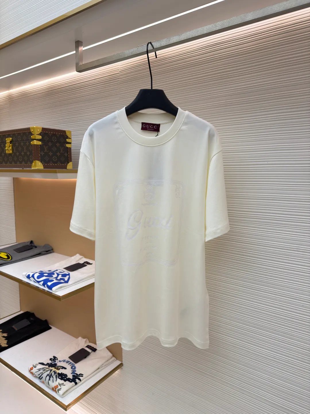 Gucci Buddha City printed round neck short sleeves ●Original version: purchased and developed by 5039 ●Item number: 1682280-A00 ●Fabric: soft knitted cotton fabric ●Technology: glue printing ●Color: apricot ●Version: fitted version ●Weight: about 245 grams ●Size: XS-S-M-L ●Description: This product is made of 60-count single-yarn double-sided knitted cotton with a weight of 170g/㎡; the neckline and other parts are matched with 32-count double-yarn ribbing. The high weight ensures a stable collar shape. 60 counts is an extremely high count, which means the yarn is extremely fine, which directly gives the fabric an extraordinary delicate, silky and soft touch. The front and back sides of the double-sided fabric have the same texture, which is uniform, thin and elastic. The weight of 170g is lightweight, ensuring the T-shirt is extremely light, breathable and drapey. It is almost invisible when worn and is very suitable for early spring. The color of the fabric is soft and high-end, which further enhances the exquisite texture of the fabric. The direct expression of the printing collection elements uses the environmentally friendly elastic thick plate bright glue printing process to place such a three-dimensional, bright, and highly present slogan printing on the simple sweater. This is a high-end special printing technology. Thick plate means that the slurry is accumulated thickly, which can form an obvious three-dimensional effect; after the bright slurry is cured, the surface will show a high-gloss glossy effect; the slurry itself is elastic and can stretch with the fabric. The special environmentally friendly elastic bright slurry is transferred through thick coating on the screen and then solidified at high temperature. Create a brand slogan pattern with significant 3D raised texture, mirror-like luster, and strong stretch resistance. To the touch, the pattern area has obvious stiff bulges and a smooth lacquered surface, which forms a strong contrast with the extremely soft fabric base and has a strong visual impact. The overall wiring is straight and delicate, the fabric is comfortable and soft, and the color is consistent without color difference. It can be matched with the same style to create a fashionable look and control various occasions. Customized accessories, complete with three standards, same style for men and women!