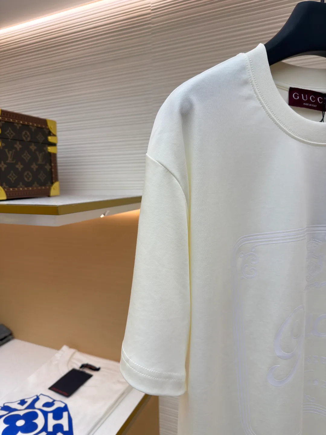 Gucci Buddha City printed round neck short sleeves ●Original version: purchased and developed by 5039 ●Item number: 1682280-A00 ●Fabric: soft knitted cotton fabric ●Technology: glue printing ●Color: apricot ●Version: fitted version ●Weight: about 245 grams ●Size: XS-S-M-L ●Description: This product is made of 60-count single-yarn double-sided knitted cotton with a weight of 170g/㎡; the neckline and other parts are matched with 32-count double-yarn ribbing. The high weight ensures a stable collar shape. 60 counts is an extremely high count, which means the yarn is extremely fine, which directly gives the fabric an extraordinary delicate, silky and soft touch. The front and back sides of the double-sided fabric have the same texture, which is uniform, thin and elastic. The weight of 170g is lightweight, ensuring the T-shirt is extremely light, breathable and drapey. It is almost invisible when worn and is very suitable for early spring. The color of the fabric is soft and high-end, which further enhances the exquisite texture of the fabric. The direct expression of the printing collection elements uses the environmentally friendly elastic thick plate bright glue printing process to place such a three-dimensional, bright, and highly present slogan printing on the simple sweater. This is a high-end special printing technology. Thick plate means that the slurry is accumulated thickly, which can form an obvious three-dimensional effect; after the bright slurry is cured, the surface will show a high-gloss glossy effect; the slurry itself is elastic and can stretch with the fabric. The special environmentally friendly elastic bright slurry is transferred through thick coating on the screen and then solidified at high temperature. Create a brand slogan pattern with significant 3D raised texture, mirror-like luster, and strong stretch resistance. To the touch, the pattern area has obvious stiff bulges and a smooth lacquered surface, which forms a strong contrast with the extremely soft fabric base and has a strong visual impact. The overall wiring is straight and delicate, the fabric is comfortable and soft, and the color is consistent without color difference. It can be matched with the same style to create a fashionable look and control various occasions. Customized accessories, complete with three standards, same style for men and women!