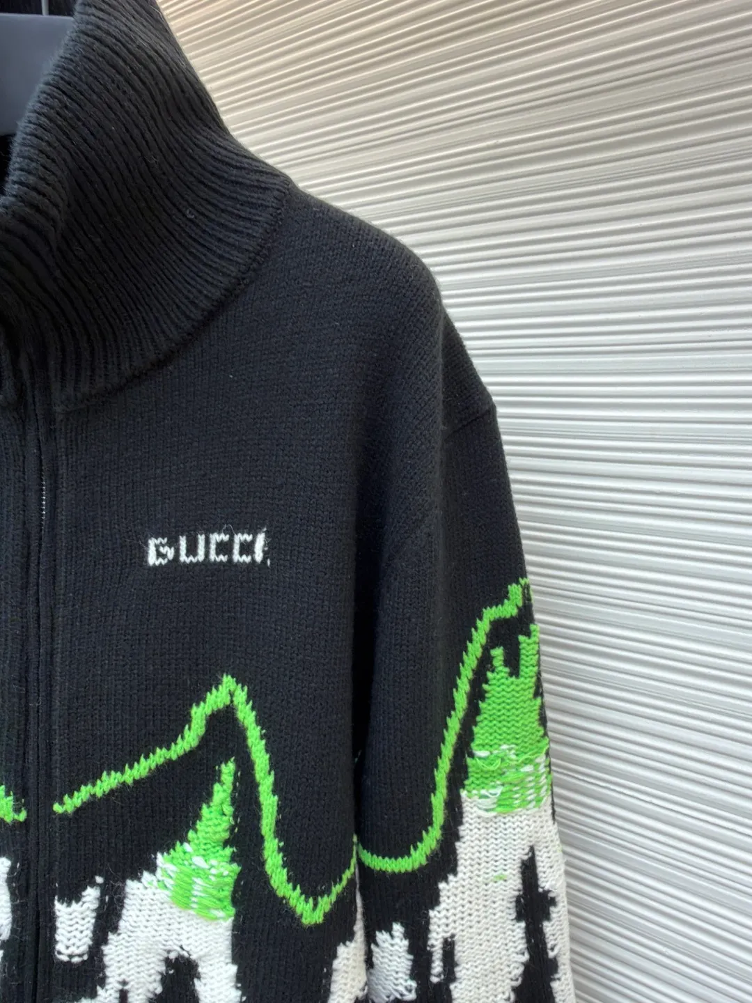 Gucci ski-embellished mountain view intarsia wool knitted jacket ●Original version: purchased and developed by 30686 ●Item number: 1681937-C65 ●Fabric: wool blended fabric ●Technology: knitted intarsia production ●Color: black, green and white ●Version: fitted version ●Weight: about 875 grams ●Size: S-M-L-XL ●Description: This Gucci snow mountain knitted cardigan uses 7-needle high-density jacquard technology and is formed by imported intelligent computerized wool looms. The main body is made of custom-dyed refined cotton blended yarn, which has been twisted and spliced ​​to have both a crisp texture and soft and skin-friendly properties. The yarn has been treated with the Basulan process in advance, which has a high degree of color restoration and is not easy to fade. The "snow mountain" pattern on the body adopts double-layer intarsia technology, and the three colors of black, white and fluorescent green are accurately interwoven through the German heavy industry jacquard machine. The pattern outline is clear and the texture is distinct. The placket is equipped with a customized metal zipper, and the bottom of the zipper is reinforced with 14-needle flat knitting; the collar, cuffs, and hem are ribbed with the same material, which has long-lasting elasticity and is not easily deformed. The finished product needs to be manually stitched and tightened, and the details are manually highlighted, and then washed and shaped with customized lotion to finally achieve the dual restoration of pattern and texture. The overall wiring is straight and delicate, the fabric is comfortable and soft, and the color is consistent without color difference. It can be matched with the same style to create a fashionable look and control various occasions. Customized accessories, complete with three standards, same style for men and women!