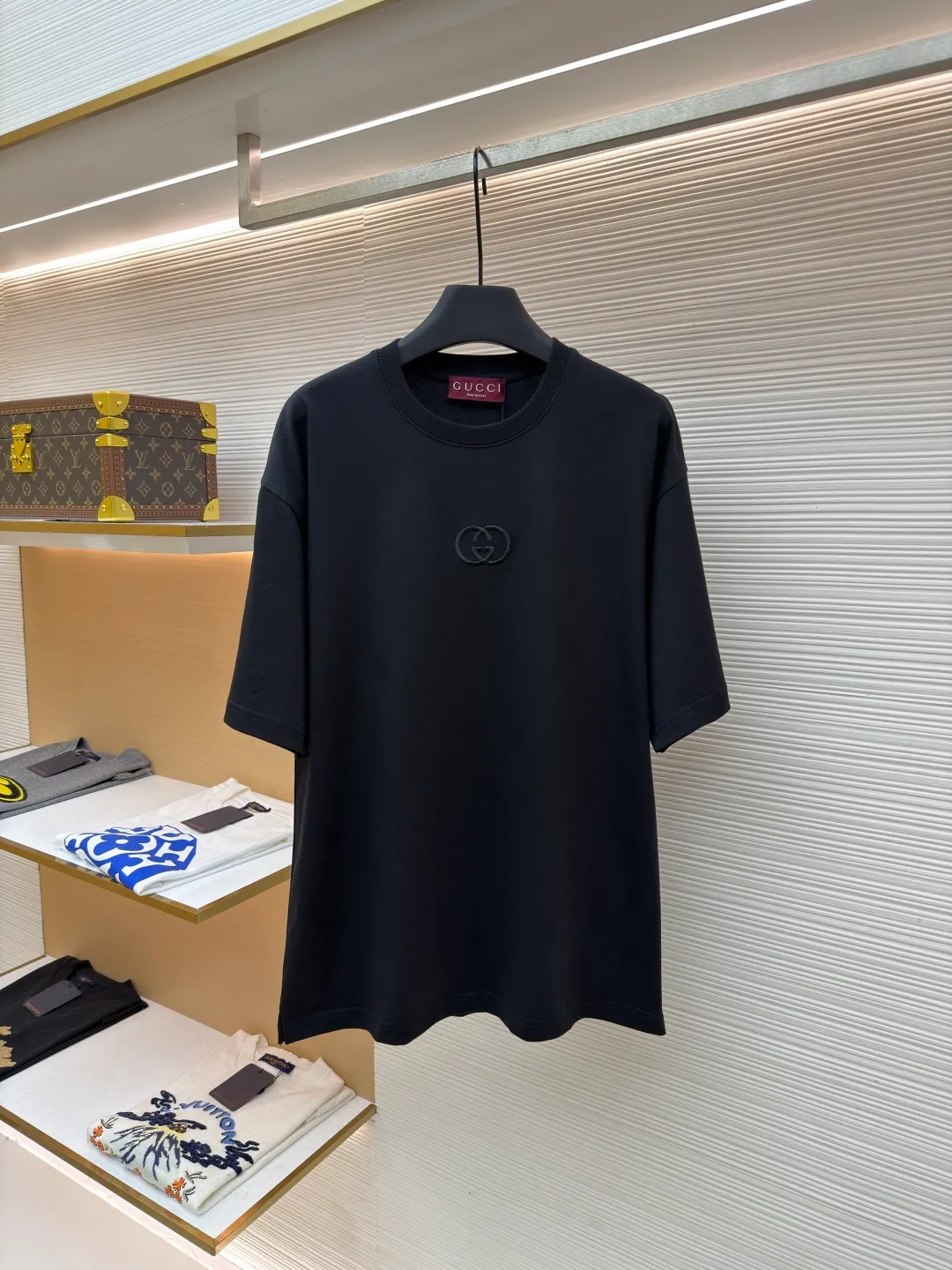 Gucci Double G embroidered round neck short sleeves ●Original version: purchased and developed by 2977 ●Item number: 1682217-A00 ●Fabric: fine velvet knitted cotton fabric ●Technology: embroidery production ●Color: black ●Version: fitted version ●Weight: about 280 grams ●Size: XS-S-M-L ●Description: Made of 15S special woven compact cotton fine velvet knitted fabric with a weight of 230g/㎡; paired with 32S high count and high weight 1x1 rib, with a weight of 340g/㎡. Ribbing is used on the collar to ensure excellent elastic recovery and deformation resistance of the collar. The fabric uses compact spinning technology to effectively reduce yarn hairiness, making the fabric structure tighter, the surface smoother, and the pilling resistance better. The weight of 230g is medium to heavy, which gives the T-shirt good stiffness and drape, and is not easy to collapse, ensuring the texture of high-end ready-to-wear. The fine velvet knitted fabric has been lightly brushed or raised, giving it a softer, waxier skin-friendly feel than ordinary plain cotton. Three-dimensional stitch embroidery is an embroidery process that uses high-density linear stitches to be closely arranged to form raised lines. The core is to use thicker embroidery thread, and the stitches are continuous and even without gaps. It naturally produces a raised height of 1-2 mm, making the edges of the pattern clear and sharp, and the touch feeling full and solid. The overall wiring is straight and delicate, the fabric is comfortable and soft, and the color is consistent without color difference. It can be matched with the same style to create a fashionable look and control various occasions. Customized accessories, complete with three standards, same style for men and women!