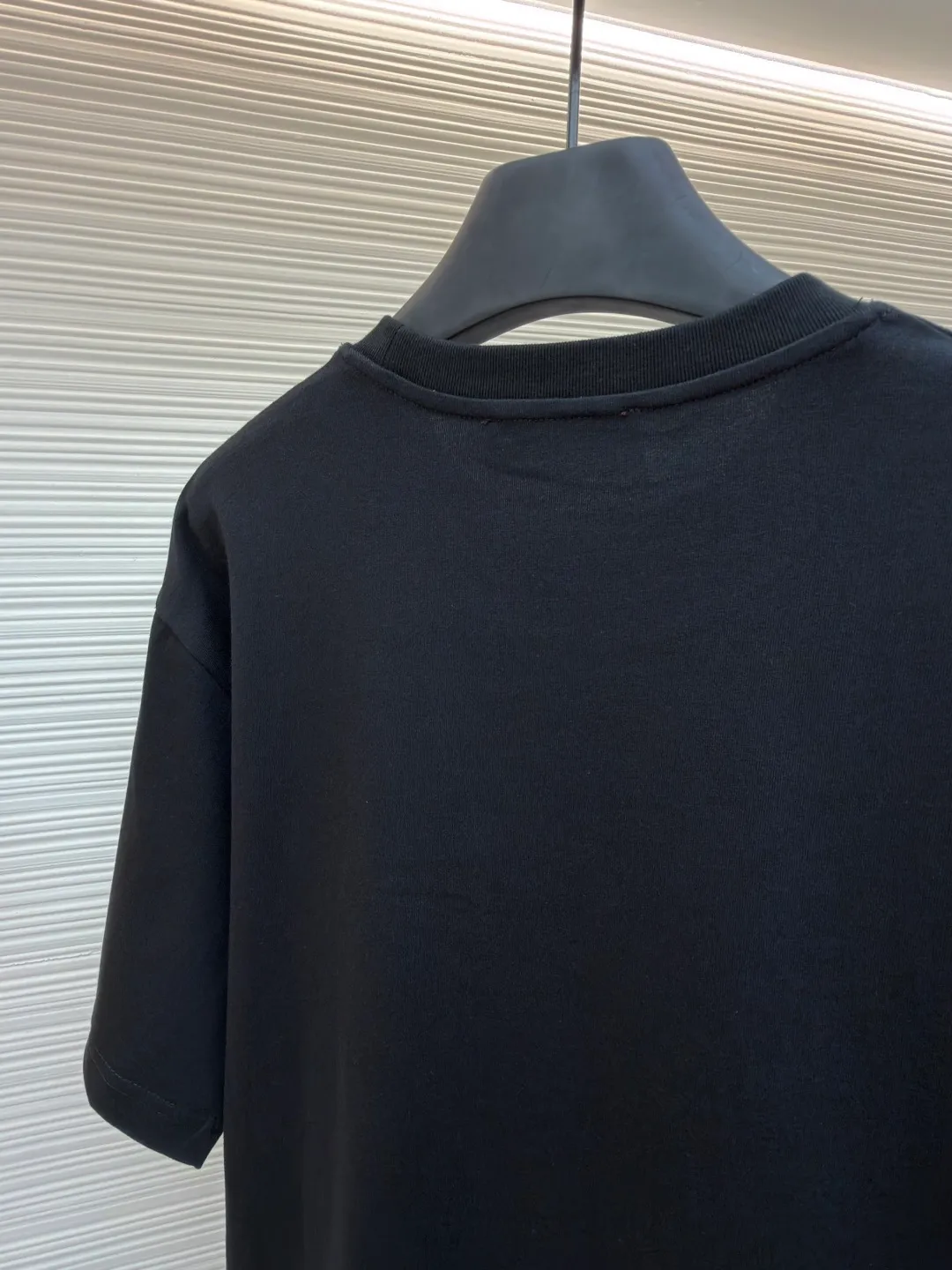 Gucci Double G embroidered round neck short sleeves ●Original version: purchased and developed by 2977 ●Item number: 1682217-A00 ●Fabric: fine velvet knitted cotton fabric ●Technology: embroidery production ●Color: black ●Version: fitted version ●Weight: about 280 grams ●Size: XS-S-M-L ●Description: Made of 15S special woven compact cotton fine velvet knitted fabric with a weight of 230g/㎡; paired with 32S high count and high weight 1x1 rib, with a weight of 340g/㎡. Ribbing is used on the collar to ensure excellent elastic recovery and deformation resistance of the collar. The fabric uses compact spinning technology to effectively reduce yarn hairiness, making the fabric structure tighter, the surface smoother, and the pilling resistance better. The weight of 230g is medium to heavy, which gives the T-shirt good stiffness and drape, and is not easy to collapse, ensuring the texture of high-end ready-to-wear. The fine velvet knitted fabric has been lightly brushed or raised, giving it a softer, waxier skin-friendly feel than ordinary plain cotton. Three-dimensional stitch embroidery is an embroidery process that uses high-density linear stitches to be closely arranged to form raised lines. The core is to use thicker embroidery thread, and the stitches are continuous and even without gaps. It naturally produces a raised height of 1-2 mm, making the edges of the pattern clear and sharp, and the touch feeling full and solid. The overall wiring is straight and delicate, the fabric is comfortable and soft, and the color is consistent without color difference. It can be matched with the same style to create a fashionable look and control various occasions. Customized accessories, complete with three standards, same style for men and women!