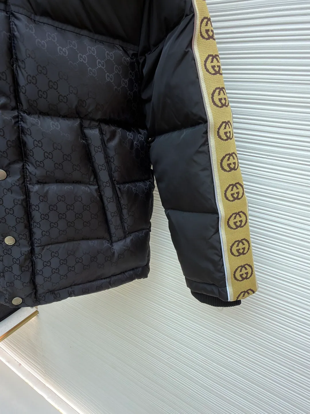Gucci full-print webbing nylon down jacket ●Original version: purchased and developed by 10929 ●Item number: 1681831-C85 ●Fabric: goose down fabric ●Technology: mechanical down filling ●Color: black ●Version: fitted version ●Weight: about 1120 grams ●Size: 42-44-46-48-50 ●Description: This Gucci patchwork down jacket uses collision splicing technology: the body is made of high-density matte nylon, embossed with the brand's classic double G dark pattern, and heat-pressed shaping technology is used to ensure the three-dimensionality of the pattern; the shoulders and sleeves are made of glossy nylon fabric, with side webbing (full-print Double G logo). The webbing is connected to the body through precision sewing technology, and the edges are neatly seamed. It uses segmented down filling quilting to accurately control the amount of down filling according to areas, taking into account both warmth and style. The hood is designed with a metal adjustment buckle, the placket is closed with a metal snap button, and the cuffs and hem are elastic ribbed. The overall design is 3D cut, and the material contrast in the details echoes the logo, which not only retains brand recognition, but also enhances the comfort and functionality of wearing. The overall wiring is straight and delicate, the fabric is comfortable and soft, and the color is consistent without color difference. It can be matched with the same style to create a fashionable look and control various occasions. Customized accessories, complete with three standards, same style for men and women!