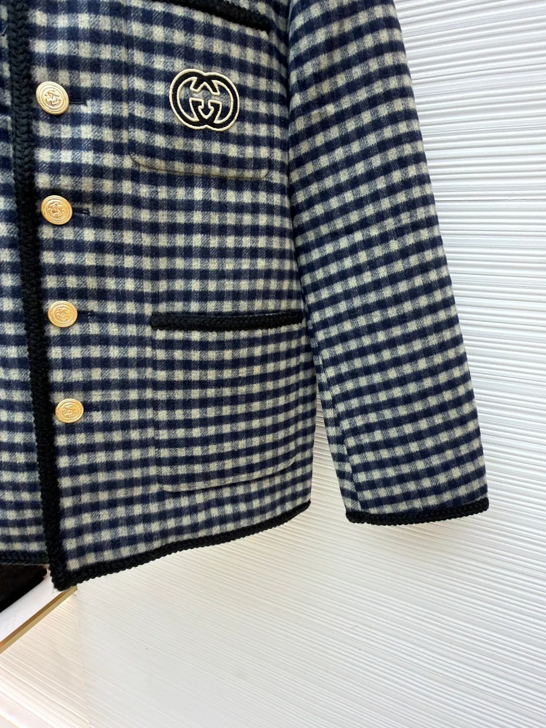 Gucci double-sided woolen jacket with G decoration ●Original version: Purchased and developed for 32900 ●Item number: 1681537-E00 ●Fabric: wool blended fabric ●Technology: embroidery production ●Color: black and white plaid ●Version: fitted version ●Weight: about 1055 grams ●Size: 44-46-48-50 ●Description: The fabric is made of [semi-worsted wool fabric], [wool content 80% + 20% acrylic], [rapier machine woven gray cloth], [print-dyed warp color], [hand-pulled white blue warp on double warp beams], [double-sided large heaven and earth axis Jacquard], the front [two-color plaid twill pattern], and the bottom [big G letter grid pattern]. In the early stage, nearly one hundred kilograms of yarn were spent on pattern making to measure the pattern shrinkage, and adjust the pattern size of the embryonic fabric to ensure that the pattern of the finished fabric was the same size as the Y version after brushing and washing. It adopts [Hand-cut horizontal strips on the front and rear panels to match the flowers], three pockets [cut with horizontal strips and vertical strips to restore the flowers], the cut pieces and the front panels are all [hand-written numbers] to ensure perfect alignment for sewing, and [sweeping powder to position and draw circles], inside [circular pockets on dark lines], which can make the pockets smooth and restore the flowers, which requires extremely high technical requirements for workers, [hand-crank embroidery machine to affix GG stamps], [Japanese imported Tajima embroidery machine] embroidery, [Flat embroidered seam seals after hand trimming] on the machine, [flat contrasting webbing on the bag edges and placket], the webbing is made of [hand-woven polyester glossy filament], all hems are [hand-picked hem sealing], [mold-made custom-made bronze gold anchor hand-sewn buttons]. The overall wiring is straight and delicate, the fabric is comfortable and soft, and the color is consistent without color difference. It can be matched with the same style to create a fashionable look and control various occasions. Customized accessories, complete with three standards, same style for men and women!