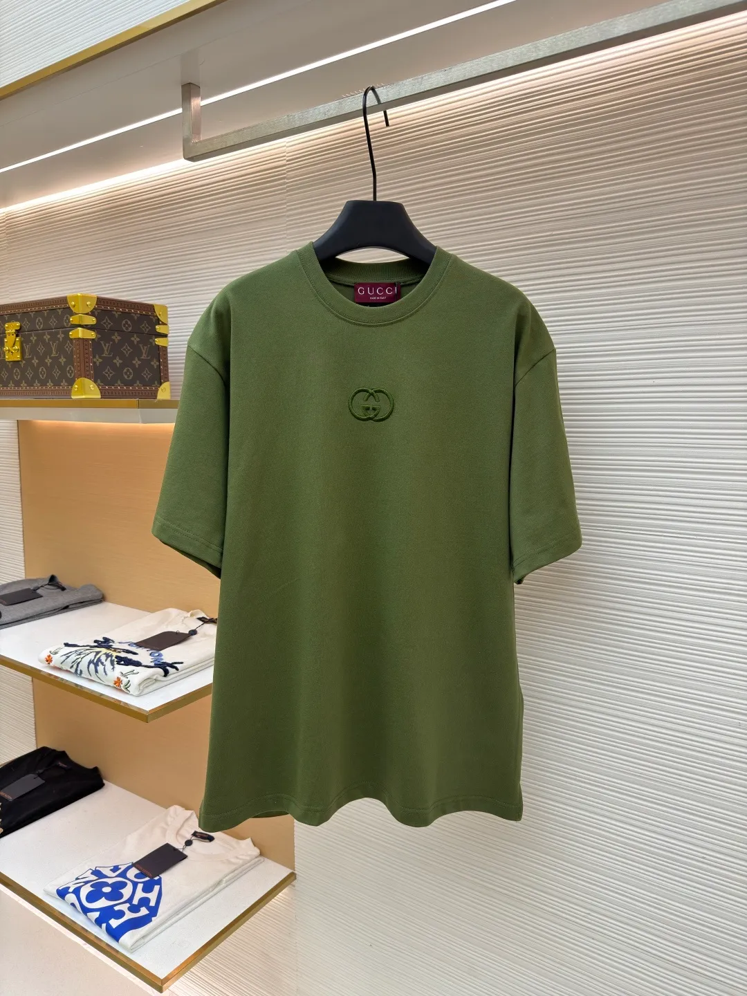 Gucci Double G embroidered round neck short sleeves ●Original version: Purchased and developed for 5300 ●Item number: 1682499-X90 ●Fabric: fine velvet knitted cotton fabric ●Technology: embroidery production ●Color: green ●Version: fitted version ●Weight: about 290 grams ●Size: S-M-L-XL ●Description: Made of 15S special woven compact cotton fine velvet knitted fabric with a weight of 230g/㎡; paired with 32S high count and high weight 1x1 rib, with a weight of 340g/㎡. Ribbing is used on the collar to ensure excellent elastic recovery and deformation resistance of the collar. The fabric uses compact spinning technology to effectively reduce yarn hairiness, making the fabric structure tighter, the surface smoother, and the pilling resistance better. The weight of 230g is medium to heavy, which gives the T-shirt good stiffness and drape, and is not easy to collapse, ensuring the texture of high-end ready-to-wear. The fine velvet knitted fabric has been lightly brushed or raised, giving it a softer, waxier skin-friendly feel than ordinary plain cotton. Three-dimensional stitch embroidery is an embroidery process that uses high-density linear stitches to be closely arranged to form raised lines. The core is to use thicker embroidery thread, and the stitches are continuous and even without gaps. It naturally produces a raised height of 1-2 mm, making the edges of the pattern clear and sharp, and the touch feeling full and solid. The overall wiring is straight and delicate, the fabric is comfortable and soft, and the color is consistent without color difference. It can be matched with the same style to create a fashionable look and control various occasions. Customized accessories, complete with three standards, same style for men and women!