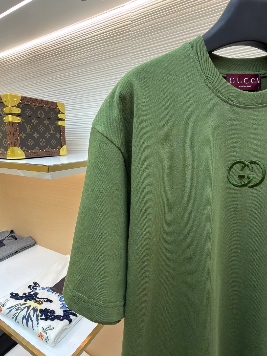 Gucci Double G embroidered round neck short sleeves ●Original version: Purchased and developed for 5300 ●Item number: 1682499-X90 ●Fabric: fine velvet knitted cotton fabric ●Technology: embroidery production ●Color: green ●Version: fitted version ●Weight: about 290 grams ●Size: S-M-L-XL ●Description: Made of 15S special woven compact cotton fine velvet knitted fabric with a weight of 230g/㎡; paired with 32S high count and high weight 1x1 rib, with a weight of 340g/㎡. Ribbing is used on the collar to ensure excellent elastic recovery and deformation resistance of the collar. The fabric uses compact spinning technology to effectively reduce yarn hairiness, making the fabric structure tighter, the surface smoother, and the pilling resistance better. The weight of 230g is medium to heavy, which gives the T-shirt good stiffness and drape, and is not easy to collapse, ensuring the texture of high-end ready-to-wear. The fine velvet knitted fabric has been lightly brushed or raised, giving it a softer, waxier skin-friendly feel than ordinary plain cotton. Three-dimensional stitch embroidery is an embroidery process that uses high-density linear stitches to be closely arranged to form raised lines. The core is to use thicker embroidery thread, and the stitches are continuous and even without gaps. It naturally produces a raised height of 1-2 mm, making the edges of the pattern clear and sharp, and the touch feeling full and solid. The overall wiring is straight and delicate, the fabric is comfortable and soft, and the color is consistent without color difference. It can be matched with the same style to create a fashionable look and control various occasions. Customized accessories, complete with three standards, same style for men and women!