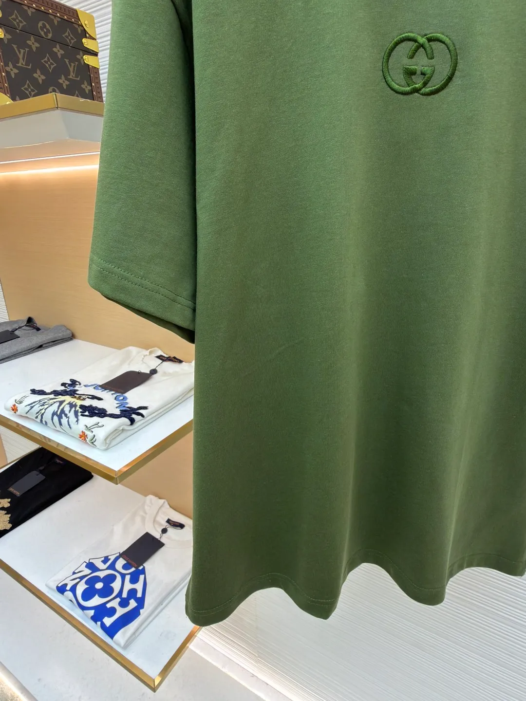 Gucci Double G embroidered round neck short sleeves ●Original version: Purchased and developed for 5300 ●Item number: 1682499-X90 ●Fabric: fine velvet knitted cotton fabric ●Technology: embroidery production ●Color: green ●Version: fitted version ●Weight: about 290 grams ●Size: S-M-L-XL ●Description: Made of 15S special woven compact cotton fine velvet knitted fabric with a weight of 230g/㎡; paired with 32S high count and high weight 1x1 rib, with a weight of 340g/㎡. Ribbing is used on the collar to ensure excellent elastic recovery and deformation resistance of the collar. The fabric uses compact spinning technology to effectively reduce yarn hairiness, making the fabric structure tighter, the surface smoother, and the pilling resistance better. The weight of 230g is medium to heavy, which gives the T-shirt good stiffness and drape, and is not easy to collapse, ensuring the texture of high-end ready-to-wear. The fine velvet knitted fabric has been lightly brushed or raised, giving it a softer, waxier skin-friendly feel than ordinary plain cotton. Three-dimensional stitch embroidery is an embroidery process that uses high-density linear stitches to be closely arranged to form raised lines. The core is to use thicker embroidery thread, and the stitches are continuous and even without gaps. It naturally produces a raised height of 1-2 mm, making the edges of the pattern clear and sharp, and the touch feeling full and solid. The overall wiring is straight and delicate, the fabric is comfortable and soft, and the color is consistent without color difference. It can be matched with the same style to create a fashionable look and control various occasions. Customized accessories, complete with three standards, same style for men and women!