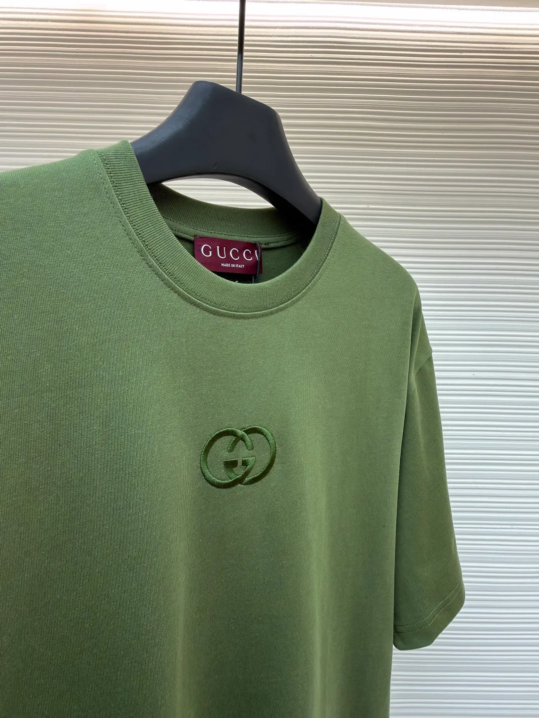 Gucci Double G embroidered round neck short sleeves ●Original version: Purchased and developed for 5300 ●Item number: 1682499-X90 ●Fabric: fine velvet knitted cotton fabric ●Technology: embroidery production ●Color: green ●Version: fitted version ●Weight: about 290 grams ●Size: S-M-L-XL ●Description: Made of 15S special woven compact cotton fine velvet knitted fabric with a weight of 230g/㎡; paired with 32S high count and high weight 1x1 rib, with a weight of 340g/㎡. Ribbing is used on the collar to ensure excellent elastic recovery and deformation resistance of the collar. The fabric uses compact spinning technology to effectively reduce yarn hairiness, making the fabric structure tighter, the surface smoother, and the pilling resistance better. The weight of 230g is medium to heavy, which gives the T-shirt good stiffness and drape, and is not easy to collapse, ensuring the texture of high-end ready-to-wear. The fine velvet knitted fabric has been lightly brushed or raised, giving it a softer, waxier skin-friendly feel than ordinary plain cotton. Three-dimensional stitch embroidery is an embroidery process that uses high-density linear stitches to be closely arranged to form raised lines. The core is to use thicker embroidery thread, and the stitches are continuous and even without gaps. It naturally produces a raised height of 1-2 mm, making the edges of the pattern clear and sharp, and the touch feeling full and solid. The overall wiring is straight and delicate, the fabric is comfortable and soft, and the color is consistent without color difference. It can be matched with the same style to create a fashionable look and control various occasions. Customized accessories, complete with three standards, same style for men and women!