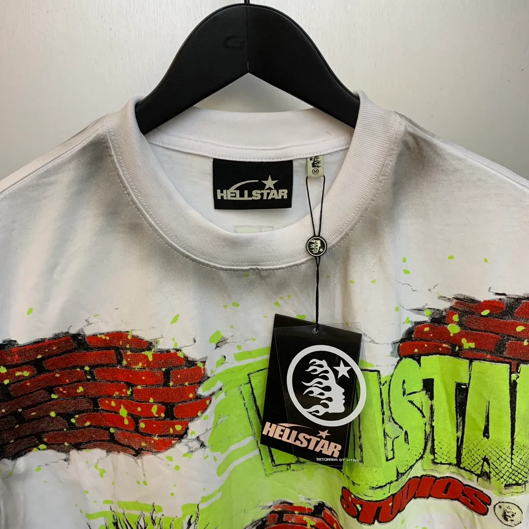 P134 HELLSTAR STUDIOS BRICK WALL T-SHIRT High-quality brick wall printed distressed short-sleeves The new hot beauty trend Hellstar!  Standard beauty and trendy workmanship, original customization (fabric, pattern, printing, hang tag, main mark, etc.), exaggerated style, explosive style, dare to break through tradition, bring adventurous new fashion experience!   YoungBoy, the most popular rapper in the youth circle, has shot a lot of models for him, and celebrities such as Dababy and Swae Lee frequently get dressed!  color: white Size: S, M, L, XL