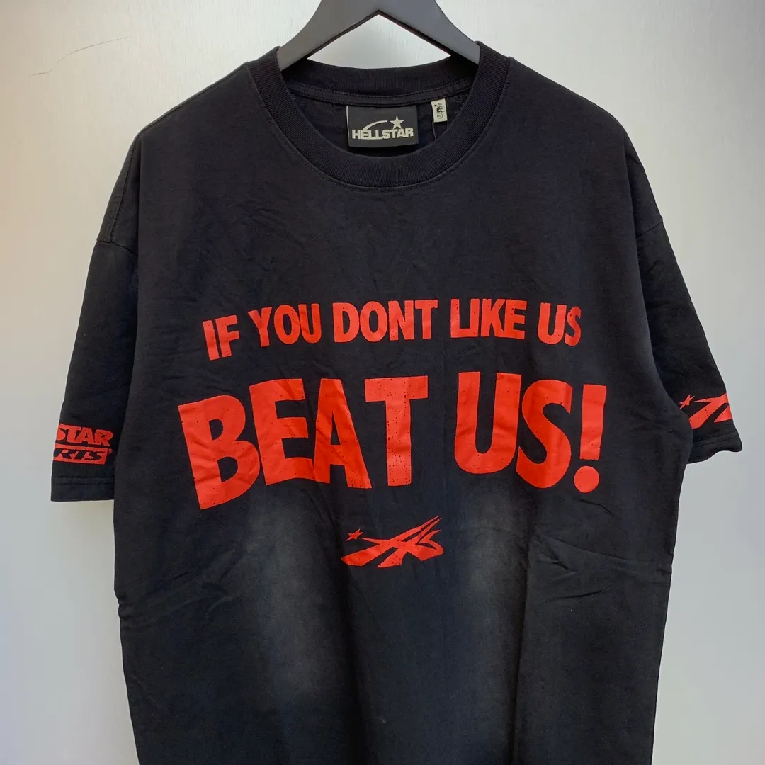 P134 Hellstar Beat Us! T-Shirt Custom Cut and sew garment manufactured in Los Angeles. Dyed and potassium sprayed with jumbo screen print. Fits slightly oversized. Gentle wash tumble dry. Dry clean preferred Newly popular Hellstar short-sleeved T-shirt!   Standard beauty and trendy workmanship, original customization (fabric, pattern, printing, hang tag, main mark, etc.), exaggerated style, explosive style, dare to break through tradition, bring adventurous new fashion experience!  YoungBoy, the most popular rapper in the youth circle, has shot a lot of models for him, and celebrities such as Dababy and Swae Lee frequently get dressed!  color: Vintage Black (washed black)