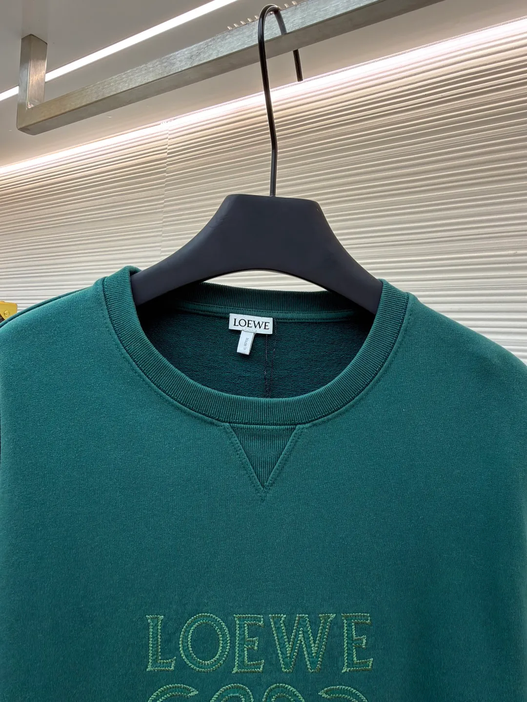 Loewe zigzag thread appliqué round neck sweatshirt ●Original version: Purchased and developed by 3621 ●Item number: 1680967-A90 ●Fabric: Fleece fabric ●Technology: Laser cutting appliqué production ●Version: Fitted version ●Weight: about 635g ●Size: 2*2 thread, 470g. The fish scale bottom fabric forms a fish scale pattern through a specific weaving process, and the plates are arranged and interwoven according to the warp and weft patterns and shapes to ensure clear texture and excellent texture. The fabric has been carefully produced and processed, and has good durability, lightness, softness, and good breathability. The edge-strengthened branches of the appliqué embroidery add a rough industrial look by imitating zigzag-shaped stitches. The appliqué stitches are in the form of trapezoidal zigzags, resembling interlaced canine teeth; emphasizing high stitch density and sharp turns, like saw blade cutting marks. Trim the seam allowance and cut off excess fabric along the dogtooth stitches to retain the jagged three-dimensional effect. After the garment is made, it is made through frying process. The garment is dyed, washed and aged using new environmentally friendly technology. Fabrics are dyed using a stone grinding method, and the garments are continuously immersed in dye and tumbled. After frying the sand, the fabric fades slightly, changing the color of the original fabric to show a nostalgic color with different shades of light and dark. The neckline adopts a structural feature formed by a V-shaped rib weaving method, which visually has a unique sense of line and extensibility. The rib structure itself has good elasticity and stretchability; inserts are added to the shoulder seams to increase the service life. The neckline, hem, and cuffs are all spliced ​​with double-needle threading. The body and sleeves are structurally split and quilted. The fabric material has high ductility and no sense of restraint. The overall wiring is straight and delicate, the fabric is comfortable and soft, and the color is consistent without color difference. It can be matched with the same style to create a fashionable look and control various occasions. Customized accessories, complete with three standards, same style for men and women!