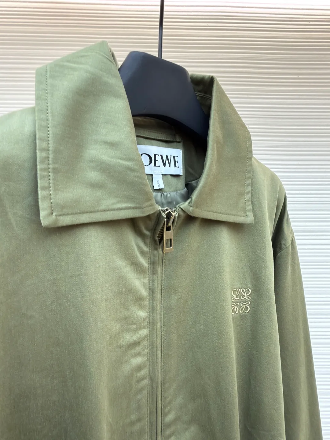 Loewe Army Green Trimmed Jacket ●Original version: Purchased and developed for 20900 ●Item number: 1682098-B40 ●Fabric: High weight dyed cotton satin fabric ●Technology: Leather patch production ●Color: Military green ●Version: Fitted version ●Weight: about 745 grams ●Size: 46-48-50-52 ●Description: Made of 100% pure cotton cloth, the fabric is dyed in the original color. The leather label is made of real cowhide composite, and the surface is stamped with gold powder to create the brand logo. The waist belt is made of multi-layer composite, and the oil edge design presents a different visual effect. Medium weight garment-dyed cotton satin jacket with gathered front and decorative contrasting belt. * Regular fit, standard length * Classic collar * Front zip closure, button cuffs * Seamed pockets, internal welt pockets * Fully lined * Anagram embroidery on chest, LOEWE embossed leather patch on back. The overall wiring is straight and delicate, the fabric is comfortable and soft, and the color is consistent without color difference. It can be matched with the same style to create a fashionable look and control various occasions. Customized accessories, complete with three standards, same style for men and women!