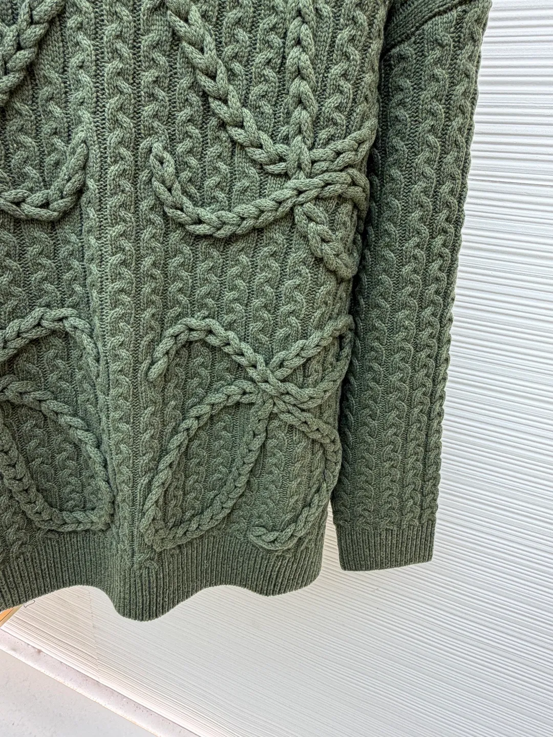Loewe Anagram twist knitted sweater ●Original version: Purchased and developed for 15900 ●Item number: 1681884-B40 ●Fabric: Wool embossed knitted fabric ●Technology: Hand-operated special machine embossed pattern making ●Color: Green ●Version: Fitted version ●Weight: about 1000g ●Size: S-M-L-XL ●Description: Custom-dyed heavyweight mercerized wool embossed knitted wool Full texture Thick and solid, natural moss green is used as the color palette to express the tranquility and power of the late autumn forest. The three-dimensional texture is used as the brush strokes. The iconic woven Loewe Anagram logo is embellished on the front. The brand's soul totem is engraved on the moss green fabric. Whimsical ideas add the finishing touch to the fashion picture. The dropped shoulder design cleverly weakens the toughness of the shoulders, making the body shape softer and giving the wearer a lazy and noble temperament. Opening up unlimited possibilities for fashion matching, the hand-operated special machine embossed pattern craftsmanship is controlled by the craftsman, the customized special knitting machine, the knitting logic of human-machine collaboration, real-time adjustment of the yarn tension, controlling the rise and fall of the knitting needles, forming a Loewe Anagram pattern with a three-dimensional concave and convex texture, and the composite double process of the global twisted rope braid. The symphonic weaving technique of hand and machine. The entire garment is made of twisted rope + webbing composite weaving, hand-connected line by line. Each row of knitting needs to complete three steps: twisting the rope, inserting the webbing, and resetting the needle bar. It takes 200-300 rows to knit a ready-made garment (time-consuming, labor-intensive, and expensive). The process of softening and deodorizing the washing water of the ready-made clothes uses professional washing equipment and specific detergents to deeply clean and deodorize the clothes to improve the feel and appearance of the clothes. The overall wiring is straight and delicate, the fabric is comfortable and soft, and the color is consistent without color difference. It can be matched with the same style to create a fashionable look, and can be used in various occasions. Customized accessories, complete with three standards, the same style for men and women.