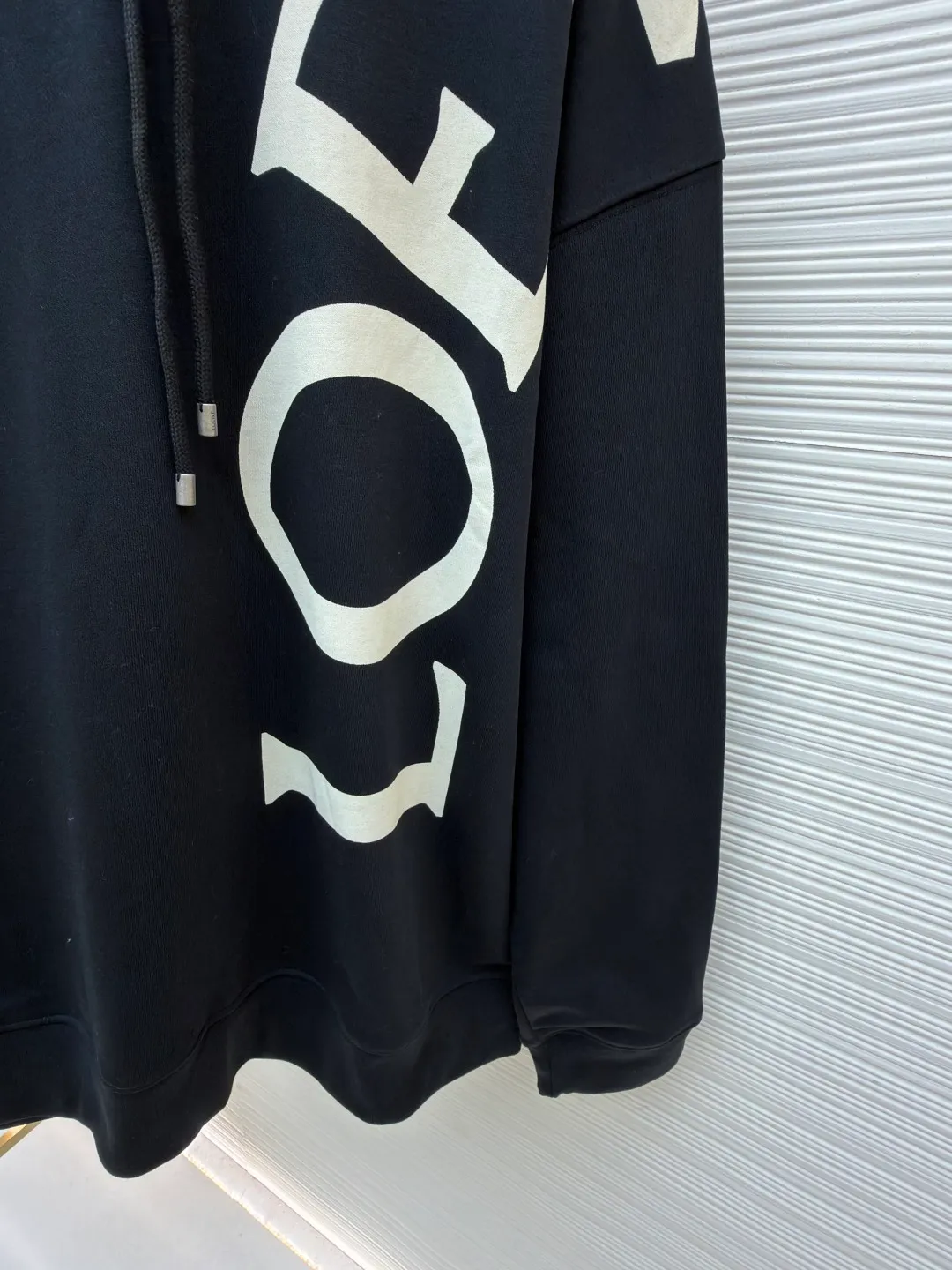 Loewe printed hooded sweatshirt ●Item number: 1682306-B00 ●Material: 100% cotton ●Technology: Printed production ●Color: black ●Version: Fitted version ●Weight: about 845 grams ●Size: S-M-L-XL ●Description: Customized high-count 100% cotton sweatshirt base fabric, as delicate as silk, comfortable and close to the skin, with deep black as the main tone, containing mystery and elegance The eye-catching white LOEWE print on the side is embellished. It declares the nobility of the brand with a bold design. It instantly becomes the focus of the visual and shows the luxurious style. Imported pulp discharge printing is printed on the dyed fabric with a discharge agent to destroy the dye to form a pattern. The printing process prints colorful patterns while discharge. The lines are clear and the pattern is fine. The color fastness is strong, and the fabric has been washed. It has a better hand feel. It is not easy to deform, not easy to shrink, not easy to fade, and maintains long-term beauty. The overall wiring is straight and delicate, the fabric is comfortable and soft, and the color is consistent without color difference. It can be matched with the same style to create a fashionable look and control various occasions. Customized accessories, complete with three standards, same style for men and women!