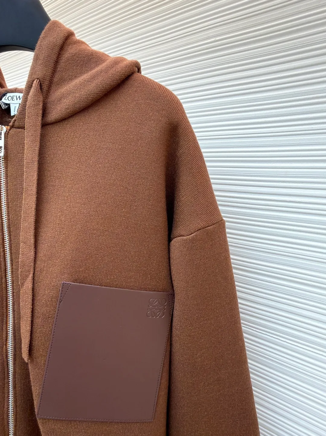 Loewe leather label pocket knitted zipper hoodie ●Original version: purchased and developed for 15900 ●Item number: 1681812-B15 ●Fabric: wool blended fabric ●Technology: knitted patch production ●Color: brown ●Version: fitted version ●Weight: about 1040 grams ●Size: S-M-L-XL ●Description: Made of 55% merino wool and woven with a 14-needle imported machine. The entire garment weighs about 960-1000 grams. The upper body shape is very three-dimensional. The thermal insulation effect is also very good when worn outside. The leather label is made of double-layer composite imitation cowhide, and the process adopts three-dimensional relief embossing technology, and the Anagram icon is embossed with high temperature. Laser positioning and wiring, each piece of clothing passes multi-layer quality inspection before being shipped. The zippers are made of No. 5 bright white electroplated zippers, the LOEWE brand logo is electroplated and engraved on the sides, and the pull teeth are made of Euler electroplated teeth. Garment washing - removal of wool impurities - color fixation - fixed fit medium weight wool hooded sweatshirt. *Regular fit, standard length*Double side seams*Hooded collar*Leather chest patch pocket*Front zip closure*Ribbed cuffs and hem*Chest pocket trim. The overall wiring is straight and delicate, the fabric is comfortable and soft, and the color is consistent without color difference. It can be matched with the same style to create a fashionable look and control various occasions. Customized accessories, complete with three standards, same style for men and women!