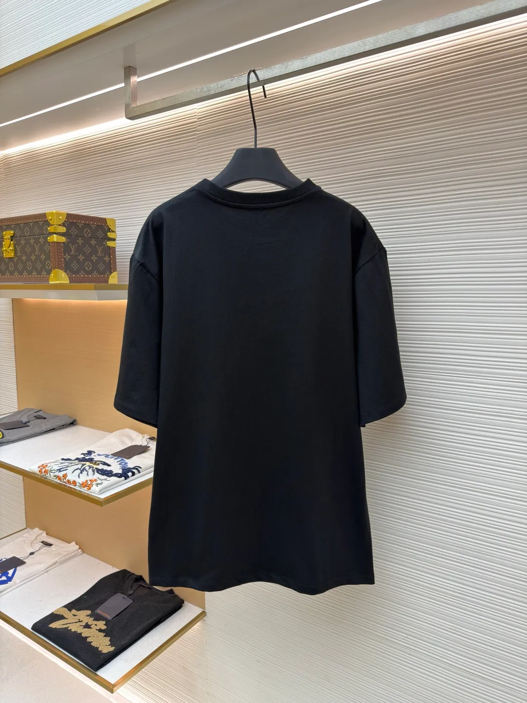 Loewe Cat Line Pattern Round Neck Short Sleeve ●Original version: Purchased and developed at 4330 ●Item number: 1681867-X85 ●Material: combed cotton fabric ●Technology: embroidery production ●Color: black ●Version: fitted version ●Weight: about 295 grams ●Size: XS-S-M-L ●Description: Made of 15S fine cotton plain fabric, 230g; with 32S double yarn thread, 300g. Plain weave fabric made from combed cotton fibers has a more orderly arrangement and higher density than ordinary cotton, so it has better texture and luster. 15S fine cotton plain fabric is a high-quality cotton fabric with the characteristics of softness, comfort, good breathability, and good durability. Anagram Embroidery Lucky Cat: The rice grain line embroidery process uses special ultra-fine embroidery thread and high-density stitching to create a pattern outline as delicate and continuous as grains. Its core feature lies in the precise arrangement of ultra-fine stitches, which require 12-15 stitches per centimeter to form full lines, and the edges present a handmade micro-waving effect. The fabric achieves a stroke-like gradient of thickness and flow. The overall pattern is light, breathable and smooth to the touch. It looks like a line outline from a distance, but the texture of interwoven fibers can be seen up close. It is especially suitable for expressing delicate details such as logo outlines and geometric borders. Anagram embroidery: Using three-dimensional embroidery technology, the logo clearly restores the spacing curve. The mercerized embroidery thread with luster is selected, combined with complex embroidery needlework and fine detail processing to create a three-dimensional relief embroidery effect. Classic trademark letter design, fine embroidery and dense stitching, clear font and strong sense of lines and three-dimensionality. The overall wiring is straight and delicate, the fabric is comfortable and soft, and the color is consistent without color difference. It can be matched with the same style to create a fashionable look and control various occasions. Customized accessories, complete with three standards, same style for men and women!