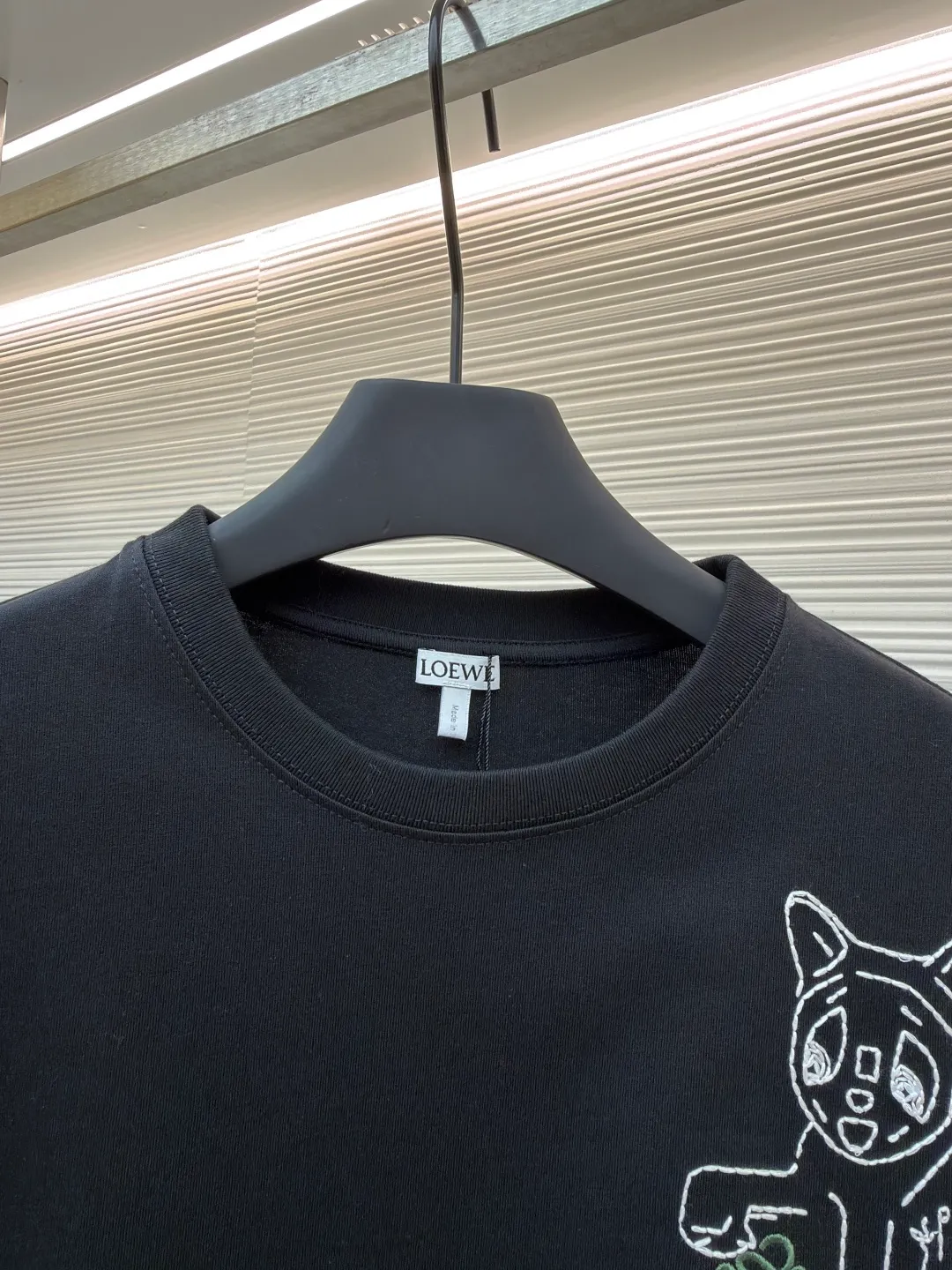Loewe Cat Line Pattern Round Neck Short Sleeve ●Original version: Purchased and developed at 4330 ●Item number: 1681867-X85 ●Material: combed cotton fabric ●Technology: embroidery production ●Color: black ●Version: fitted version ●Weight: about 295 grams ●Size: XS-S-M-L ●Description: Made of 15S fine cotton plain fabric, 230g; with 32S double yarn thread, 300g. Plain weave fabric made from combed cotton fibers has a more orderly arrangement and higher density than ordinary cotton, so it has better texture and luster. 15S fine cotton plain fabric is a high-quality cotton fabric with the characteristics of softness, comfort, good breathability, and good durability. Anagram Embroidery Lucky Cat: The rice grain line embroidery process uses special ultra-fine embroidery thread and high-density stitching to create a pattern outline as delicate and continuous as grains. Its core feature lies in the precise arrangement of ultra-fine stitches, which require 12-15 stitches per centimeter to form full lines, and the edges present a handmade micro-waving effect. The fabric achieves a stroke-like gradient of thickness and flow. The overall pattern is light, breathable and smooth to the touch. It looks like a line outline from a distance, but the texture of interwoven fibers can be seen up close. It is especially suitable for expressing delicate details such as logo outlines and geometric borders. Anagram embroidery: Using three-dimensional embroidery technology, the logo clearly restores the spacing curve. The mercerized embroidery thread with luster is selected, combined with complex embroidery needlework and fine detail processing to create a three-dimensional relief embroidery effect. Classic trademark letter design, fine embroidery and dense stitching, clear font and strong sense of lines and three-dimensionality. The overall wiring is straight and delicate, the fabric is comfortable and soft, and the color is consistent without color difference. It can be matched with the same style to create a fashionable look and control various occasions. Customized accessories, complete with three standards, same style for men and women!