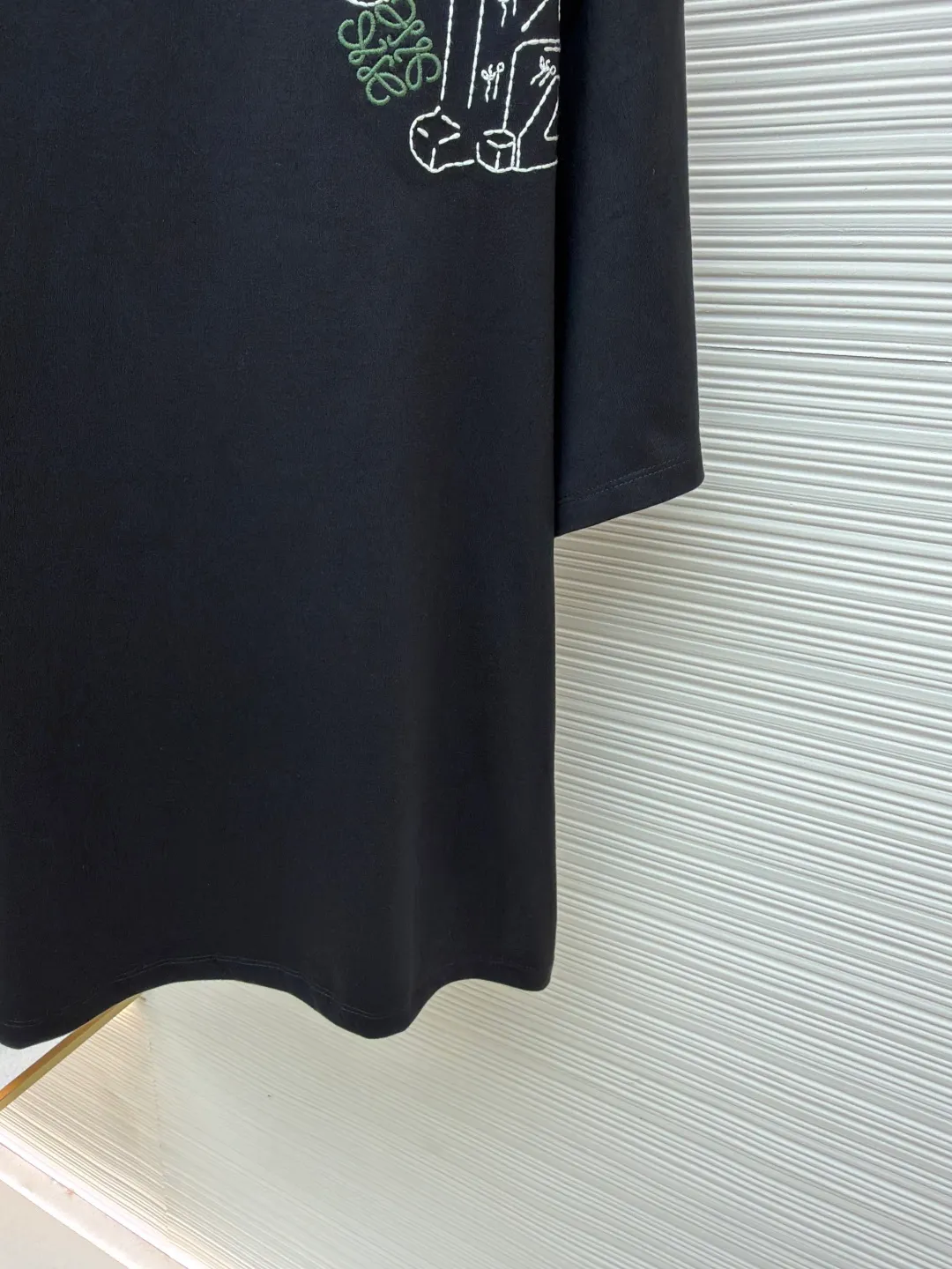 Loewe Cat Line Pattern Round Neck Short Sleeve ●Original version: Purchased and developed at 4330 ●Item number: 1681867-X85 ●Material: combed cotton fabric ●Technology: embroidery production ●Color: black ●Version: fitted version ●Weight: about 295 grams ●Size: XS-S-M-L ●Description: Made of 15S fine cotton plain fabric, 230g; with 32S double yarn thread, 300g. Plain weave fabric made from combed cotton fibers has a more orderly arrangement and higher density than ordinary cotton, so it has better texture and luster. 15S fine cotton plain fabric is a high-quality cotton fabric with the characteristics of softness, comfort, good breathability, and good durability. Anagram Embroidery Lucky Cat: The rice grain line embroidery process uses special ultra-fine embroidery thread and high-density stitching to create a pattern outline as delicate and continuous as grains. Its core feature lies in the precise arrangement of ultra-fine stitches, which require 12-15 stitches per centimeter to form full lines, and the edges present a handmade micro-waving effect. The fabric achieves a stroke-like gradient of thickness and flow. The overall pattern is light, breathable and smooth to the touch. It looks like a line outline from a distance, but the texture of interwoven fibers can be seen up close. It is especially suitable for expressing delicate details such as logo outlines and geometric borders. Anagram embroidery: Using three-dimensional embroidery technology, the logo clearly restores the spacing curve. The mercerized embroidery thread with luster is selected, combined with complex embroidery needlework and fine detail processing to create a three-dimensional relief embroidery effect. Classic trademark letter design, fine embroidery and dense stitching, clear font and strong sense of lines and three-dimensionality. The overall wiring is straight and delicate, the fabric is comfortable and soft, and the color is consistent without color difference. It can be matched with the same style to create a fashionable look and control various occasions. Customized accessories, complete with three standards, same style for men and women!