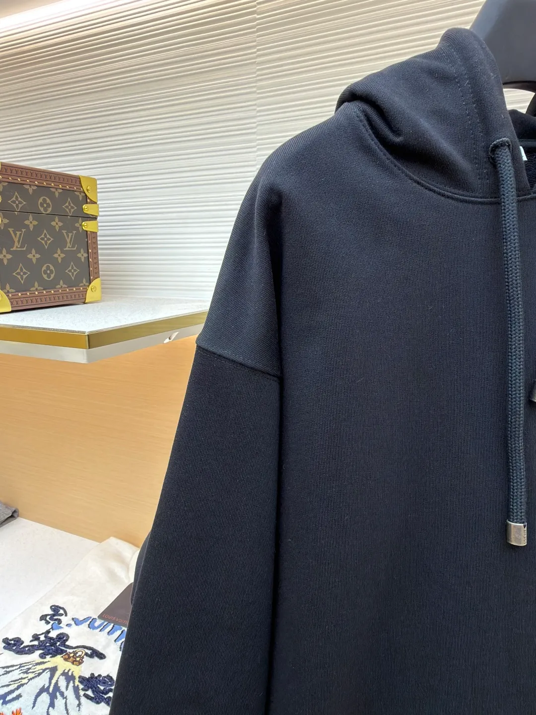Loewe quirky kitten embossed hooded sweatshirt ●Original version: Purchased and developed by 8718 ●Item number: 1681954-A85 ●Material: pure cotton fabric ●Technology: genuine leather embossed production ●Color: black ●Version: fitted version ●Weight: about 920 grams ●Size: XS-S-M-L ●Description: This LV black hooded sweatshirt is made of 380g heavyweight fleece sweatshirt fabric. It is pre-shrunk and has a stable shape, with a fine matte texture on the surface. The hat rope is made of nylon braided rope + metal bell. The rope head is polished and rhodium-plated, with a cool texture and anti-oxidation. The chest patch pocket uses genuine leather embossing technology: the leather base is embossed with brand dark patterns, and the bag surface pattern uses multi-color silk screen printing + partial flocking. The ears, paws and other details of the animal image are raised by flocking to enhance the three-dimensional effect, and the color fastness reaches level 4 or above. The body stitching adopts double-needle overlocking technology, and the ribbing on the cuffs and hem is made of the same fabric, with an elastic rebound rate of ≥85%. The overall cutting error is controlled within 0.3cm, and the brand logo is embossed on the inside of the neckline, taking into account concealment and recognition, and balancing practicality and design. The overall wiring is straight and delicate, the fabric is comfortable and soft, and the color is consistent without color difference. It can be matched with the same style to create a fashionable look and control various occasions. Customized accessories, complete with three standards, same style for men and women!