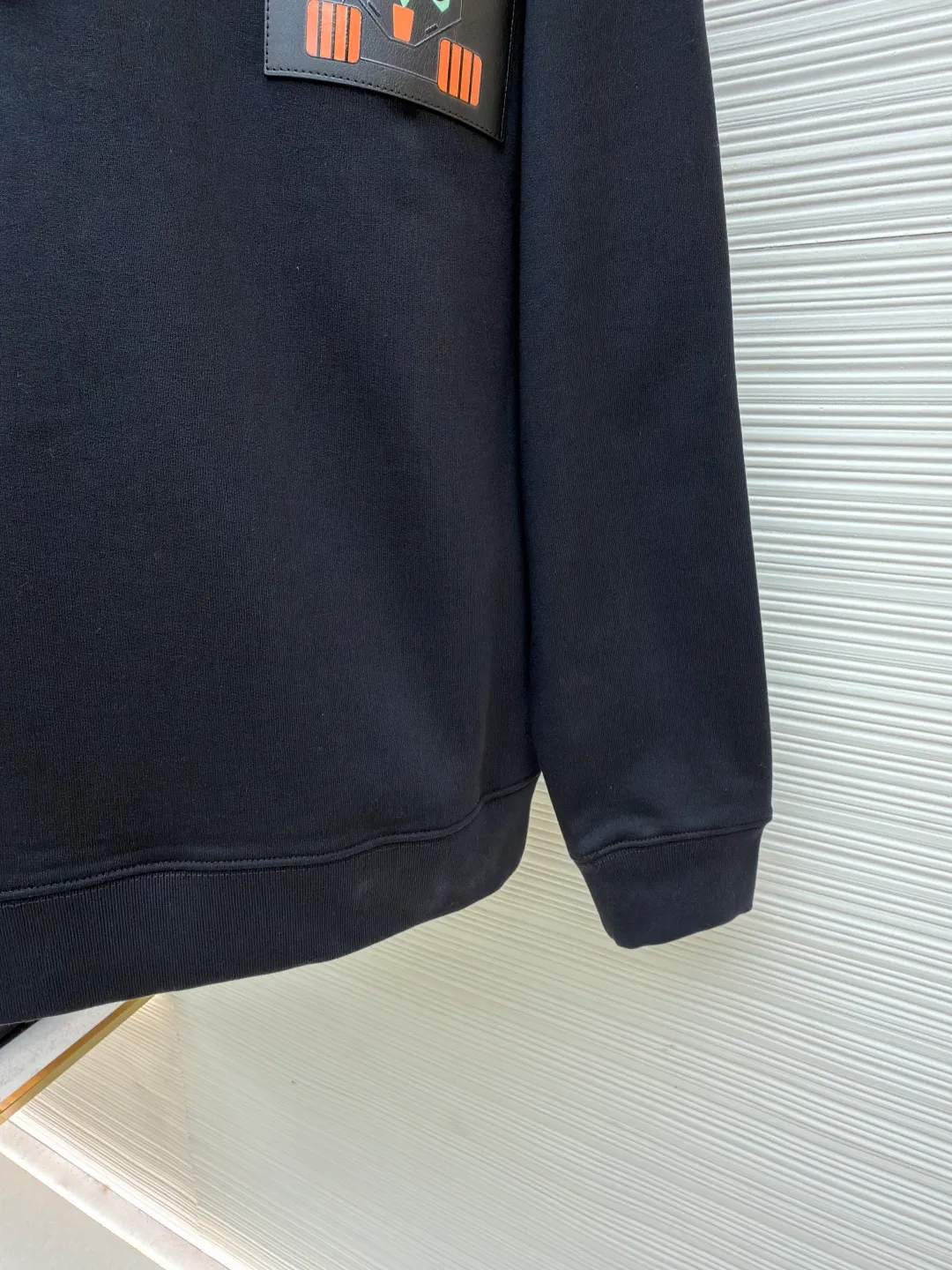 Loewe quirky kitten embossed hooded sweatshirt ●Original version: Purchased and developed by 8718 ●Item number: 1681954-A85 ●Material: pure cotton fabric ●Technology: genuine leather embossed production ●Color: black ●Version: fitted version ●Weight: about 920 grams ●Size: XS-S-M-L ●Description: This LV black hooded sweatshirt is made of 380g heavyweight fleece sweatshirt fabric. It is pre-shrunk and has a stable shape, with a fine matte texture on the surface. The hat rope is made of nylon braided rope + metal bell. The rope head is polished and rhodium-plated, with a cool texture and anti-oxidation. The chest patch pocket uses genuine leather embossing technology: the leather base is embossed with brand dark patterns, and the bag surface pattern uses multi-color silk screen printing + partial flocking. The ears, paws and other details of the animal image are raised by flocking to enhance the three-dimensional effect, and the color fastness reaches level 4 or above. The body stitching adopts double-needle overlocking technology, and the ribbing on the cuffs and hem is made of the same fabric, with an elastic rebound rate of ≥85%. The overall cutting error is controlled within 0.3cm, and the brand logo is embossed on the inside of the neckline, taking into account concealment and recognition, and balancing practicality and design. The overall wiring is straight and delicate, the fabric is comfortable and soft, and the color is consistent without color difference. It can be matched with the same style to create a fashionable look and control various occasions. Customized accessories, complete with three standards, same style for men and women!