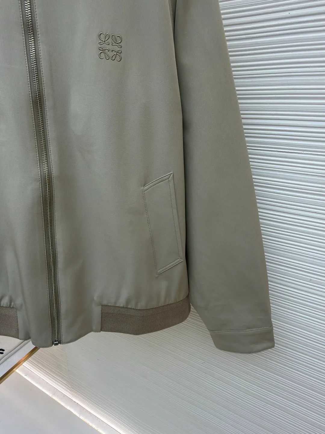 Loewe mercerized wool embroidered jacket ●Original version: purchased and developed for 20900 ●Item number: 1682266-B15 ●Fabric: wool fabric ●Technology: embroidery production ●Color: apricot ●Version: fitted version ●Weight: about 670 grams ●Size: 46-48-50-52 ●Description: Made of 40% wool, 40% linen cotton, 20% nylon. The threads are made of wool, and the surface is mercerized. The lining is made of 100% custom-dyed and custom-woven plaid fabric of the same color. The zipper uses an electroplated metal slider with electroplated pull teeth of the same color, and the brand logo is laser engraved on the side. The cuff buttons are made of natural resin buttons. The embroidery uses 3D three-dimensional embroidery, and the chest is embellished with the Anagram embroidered logo. Midweight wool and cashmere flannel jacket with ribbed knit hem and raglan sleeves. *Regular fit, standard length*High collar, snap button fastening*Zip closure at front, buttoned cuffs*Diagonal welt pockets*Anagram embossed on chest. The overall wiring is straight and delicate, the fabric is comfortable and soft, and the color is consistent without color difference. It can be matched with the same style to create a fashionable look and control various occasions. Customized accessories, complete with three standards, same style for men and women!