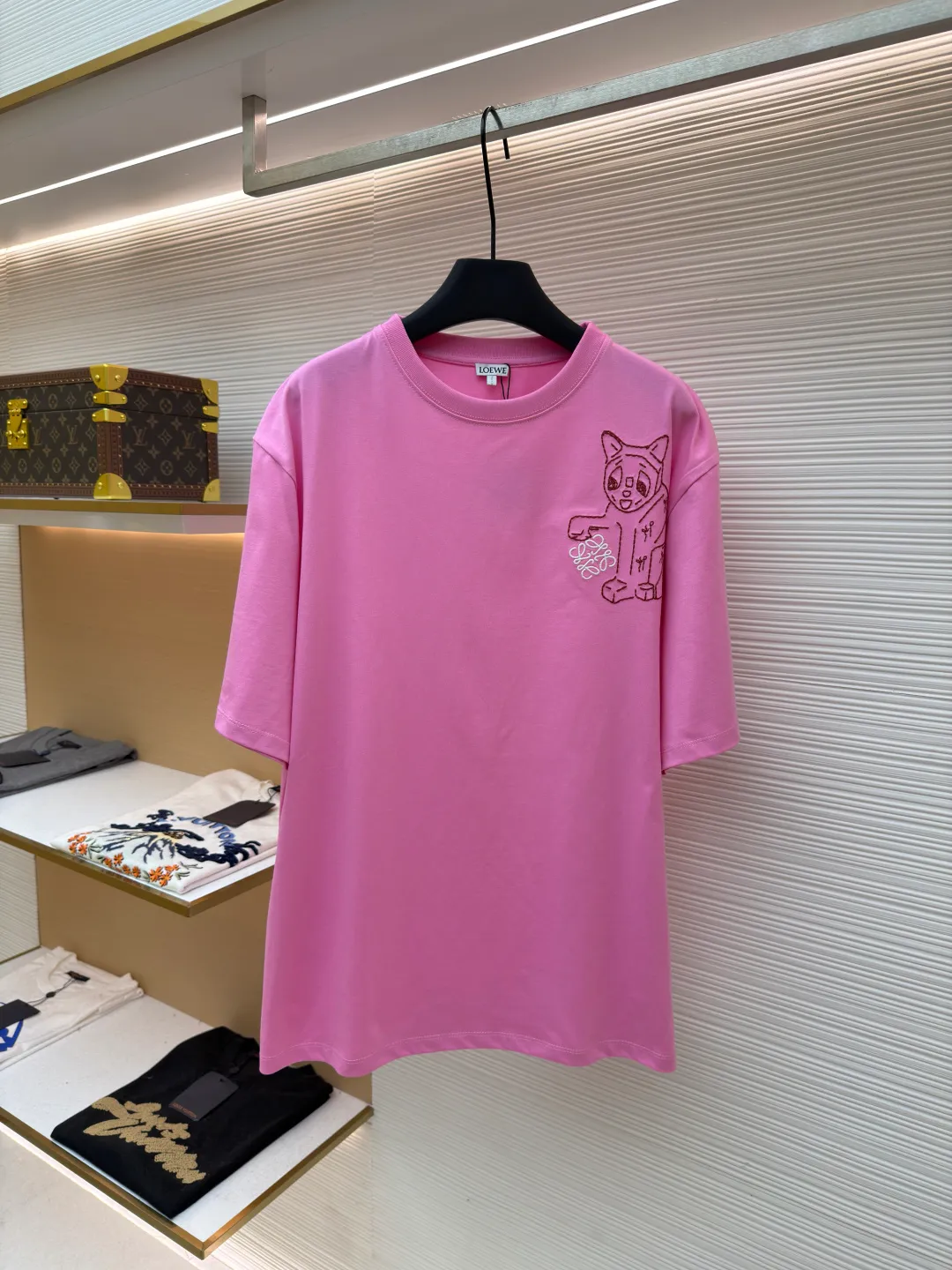 Loewe Cat Line Pattern Round Neck Short Sleeve ●Original version: Purchased and developed at 4330 ●Item number: 1681866-X85 ●Material: combed cotton fabric ●Technology: embroidery production ●Color: pink ●Version: fitted version ●Weight: about 285 grams ●Size: XS-S-M-L ●Description: Made of 15S fine cotton plain fabric, 230g; with 32S double yarn thread, 300g. Plain weave fabric made from combed cotton fibers has a more orderly arrangement and higher density than ordinary cotton, so it has better texture and luster. 15S fine cotton plain fabric is a high-quality cotton fabric with the characteristics of softness, comfort, good breathability, and good durability. Anagram Embroidery Lucky Cat: The rice grain line embroidery process uses special ultra-fine embroidery thread and high-density stitching to create a pattern outline as delicate and continuous as grains. Its core feature lies in the precise arrangement of ultra-fine stitches, which require 12-15 stitches per centimeter to form full lines, and the edges present a handmade micro-waving effect. The fabric achieves a stroke-like gradient of thickness and flow. The overall pattern is light, breathable and smooth to the touch. It looks like a line outline from a distance, but the texture of interwoven fibers can be seen up close. It is especially suitable for expressing delicate details such as logo outlines and geometric borders. Anagram embroidery: Using three-dimensional embroidery technology, the logo clearly restores the spacing curve. The mercerized embroidery thread with luster is selected, combined with complex embroidery needlework and fine detail processing to create a three-dimensional relief embroidery effect. Classic trademark letter design, fine embroidery and dense stitching, clear font and strong sense of lines and three-dimensionality. The overall wiring is straight and delicate, the fabric is comfortable and soft, and the color is consistent without color difference. It can be matched with the same style to create a fashionable look and control various occasions. Customized accessories, complete with three standards, same style for men and women!