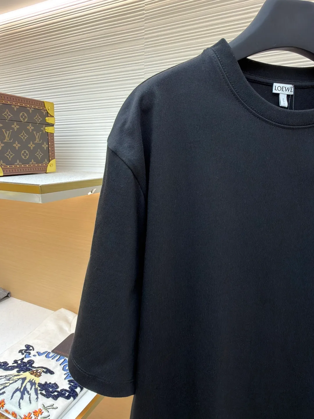 Loewe Cat Line Pattern Round Neck Short Sleeve ●Original version: Purchased and developed at 4330 ●Item number: 1681867-A00 ●Material: combed cotton fabric ●Technology: embroidery production ●Color: black ●Version: fitted version ●Weight: about 295 grams ●Size: XS-S-M-L ●Description: Made of 15S fine cotton plain fabric, 230g; with 32S double yarn thread, 300g. Plain weave fabric made from combed cotton fibers has a more orderly arrangement and higher density than ordinary cotton, so it has better texture and luster. 15S fine cotton plain fabric is a high-quality cotton fabric with the characteristics of softness, comfort, good breathability, and good durability. Anagram Embroidery Lucky Cat: The rice grain line embroidery process uses special ultra-fine embroidery thread and high-density stitching to create a pattern outline as delicate and continuous as grains. Its core feature lies in the precise arrangement of ultra-fine stitches, which require 12-15 stitches per centimeter to form full lines, and the edges present a handmade micro-waving effect. The fabric achieves a stroke-like gradient of thickness and flow. The overall pattern is light, breathable and smooth to the touch. It looks like a line outline from a distance, but the texture of interwoven fibers can be seen up close. It is especially suitable for expressing delicate details such as logo outlines and geometric borders. Anagram embroidery: Using three-dimensional embroidery technology, the logo clearly restores the spacing curve. The mercerized embroidery thread with luster is selected, combined with complex embroidery needlework and fine detail processing to create a three-dimensional relief embroidery effect. Classic trademark letter design, fine embroidery and dense stitching, clear font and strong sense of lines and three-dimensionality. The overall wiring is straight and delicate, the fabric is comfortable and soft, and the color is consistent without color difference. It can be matched with the same style to create a fashionable look and control various occasions. Customized accessories, complete with three standards, same style for men and women!