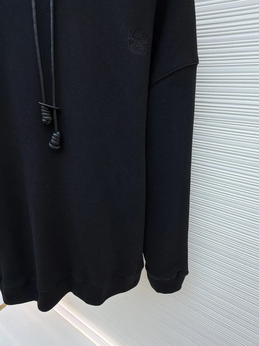 Loewe Anagram leather embroidered hooded sweatshirt ●Original version: Purchased and developed for 8800 ●Item number: 1682379-A70 ●Material: cotton fabric ●Technology: embroidery production ●Color: black ●Version: fitted version ●Weight: about 835 grams ●Size: S-M-L-XL ●Description: Customized medium-weight looped cotton wadding, soft and comfortable to the touch, wide and stylish, with pure black as the base color It outlines a simple but not simple outline. The iconic Loewe Anagram embroidery is embellished on the chest. It is paired with a Flamenco-style leather drawstring to inject a touch of unique style. It is low-key but highlights the taste. Simplify it and mix it casually to release your individual style. It adopts imported machine embroidery technology and uses advanced computer control systems and precision mechanical components to achieve Loewe Anagram embroidery operations with high precision and smooth and delicate lines. The fabrics have been washed to give them a better feel and texture. They are not easy to deform, shrink or fade, and maintain their long-lasting beauty. The overall wiring is straight and delicate, the fabric is comfortable and soft, and the color is consistent without color difference. It can be matched with the same style to create a fashionable look and control various occasions. Customized accessories, complete with three standards, same style for men and women!