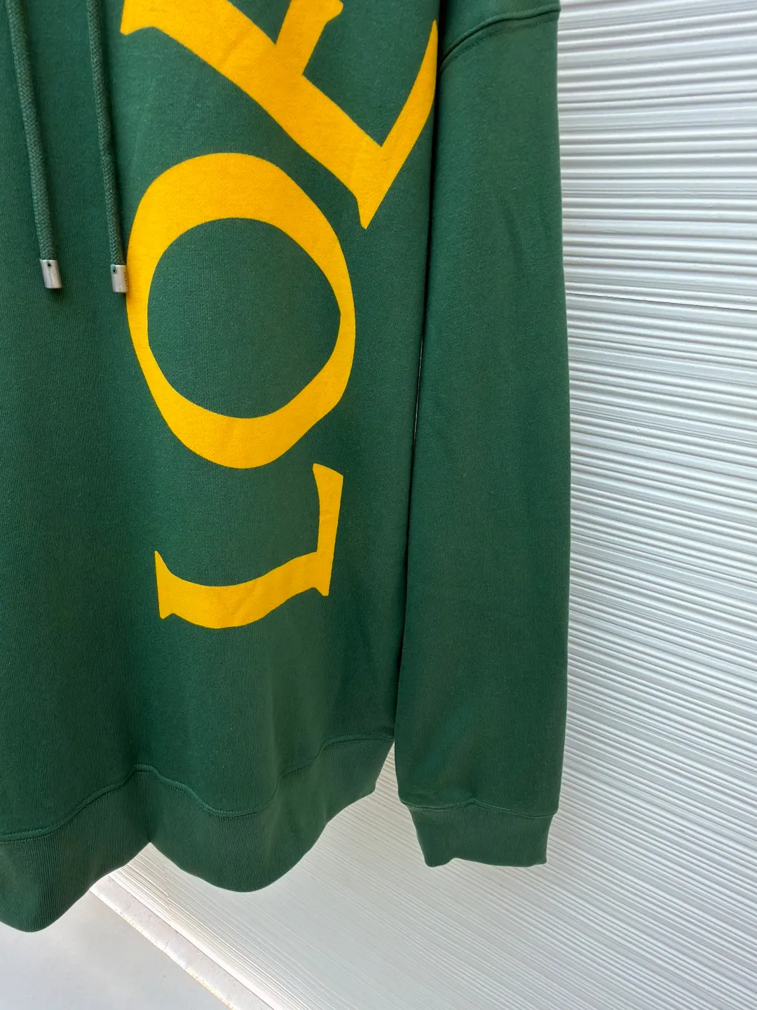 Loewe printed hooded sweatshirt ●Item No.: 1682305-B00 ●Fabric: 100% cotton ●Technology: Printed production ●Color: Green ●Version: Fitted version ●Weight: about 860 grams ●Size: S-M-L-XL ●Description: Customized high-count 100% cotton sweatshirt base fabric, as delicate as silk, comfortable and close to the skin, with deep black as the main tone, containing mystery and elegance The eye-catching white LOEWE print on the side is embellished. It declares the nobility of the brand with a bold design. It instantly becomes the focus of the visual and shows the luxurious style. Imported pulp discharge printing is printed on the dyed fabric with a discharge agent to destroy the dye to form a pattern. The printing process prints colorful patterns while discharge. The lines are clear and the pattern is fine. The color fastness is strong, and the fabric has been washed. It has a better hand feel. It is not easy to deform, not easy to shrink, not easy to fade, and maintains long-term beauty. The overall wiring is straight and delicate, the fabric is comfortable and soft, and the color is consistent without color difference. It can be matched with the same style to create a fashionable look and control various occasions. Customized accessories, complete with three standards, same style for men and women!