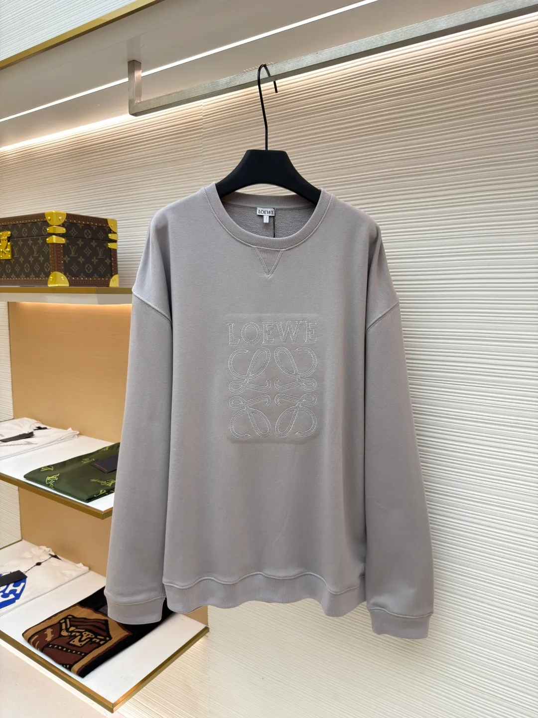 Loewe zigzag thread appliqué round neck sweatshirt ●Original version: Purchased and developed by 3621 ●Item number: 1680966-A90 ●Fabric: Fleece fabric ●Technology: Laser cutting appliqué production ●Version: Fitted version ●Weight: about 580g ●Size: 2*2 thread, 470g. The fish scale bottom fabric forms a fish scale pattern through a specific weaving process, and the plates are arranged and interwoven according to the warp and weft patterns and shapes to ensure clear texture and excellent texture. The fabric has been carefully produced and processed, and has good durability, lightness, softness, and good breathability. The edge-strengthened branches of the appliqué embroidery add a rough industrial look by imitating zigzag-shaped stitches. The appliqué stitches are in the form of trapezoidal zigzags, resembling interlaced canine teeth; emphasizing high stitch density and sharp turns, like saw blade cutting marks. Trim the seam allowance and cut off excess fabric along the dogtooth stitches to retain the jagged three-dimensional effect. After the garment is made, it is made through frying process. The garment is dyed, washed and aged using new environmentally friendly technology. Fabrics are dyed using a stone grinding method, and the garments are continuously immersed in dye and tumbled. After frying the sand, the fabric fades slightly, changing the color of the original fabric to show a nostalgic color with different shades of light and dark. The neckline adopts a structural feature formed by a V-shaped rib weaving method, which visually has a unique sense of line and extensibility. The rib structure itself has good elasticity and stretchability; inserts are added to the shoulder seams to increase the service life. The neckline, hem, and cuffs are all spliced ​​with double-needle threading. The body and sleeves are structurally split and quilted. The fabric material has high ductility and no sense of restraint. The overall wiring is straight and delicate, the fabric is comfortable and soft, and the color is consistent without color difference. It can be matched with the same style to create a fashionable look and control various occasions. Customized accessories, complete with three standards, same style for men and women!
