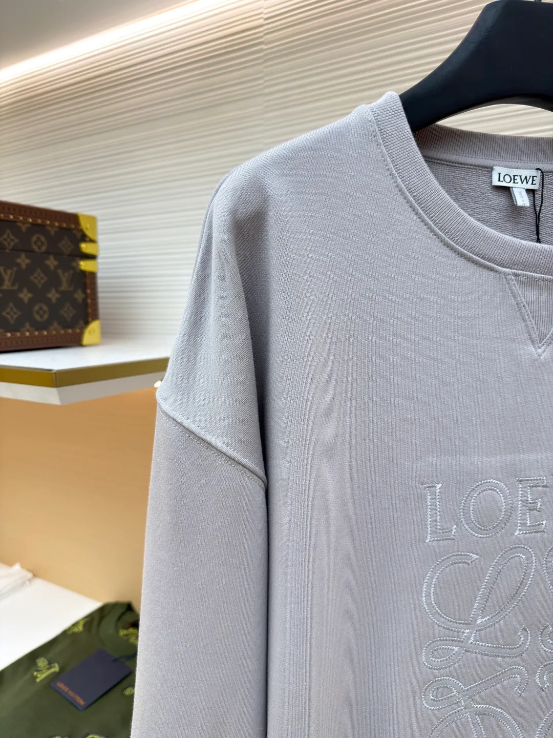 Loewe zigzag thread appliqué round neck sweatshirt ●Original version: Purchased and developed by 3621 ●Item number: 1680966-A90 ●Fabric: Fleece fabric ●Technology: Laser cutting appliqué production ●Version: Fitted version ●Weight: about 580g ●Size: 2*2 thread, 470g. The fish scale bottom fabric forms a fish scale pattern through a specific weaving process, and the plates are arranged and interwoven according to the warp and weft patterns and shapes to ensure clear texture and excellent texture. The fabric has been carefully produced and processed, and has good durability, lightness, softness, and good breathability. The edge-strengthened branches of the appliqué embroidery add a rough industrial look by imitating zigzag-shaped stitches. The appliqué stitches are in the form of trapezoidal zigzags, resembling interlaced canine teeth; emphasizing high stitch density and sharp turns, like saw blade cutting marks. Trim the seam allowance and cut off excess fabric along the dogtooth stitches to retain the jagged three-dimensional effect. After the garment is made, it is made through frying process. The garment is dyed, washed and aged using new environmentally friendly technology. Fabrics are dyed using a stone grinding method, and the garments are continuously immersed in dye and tumbled. After frying the sand, the fabric fades slightly, changing the color of the original fabric to show a nostalgic color with different shades of light and dark. The neckline adopts a structural feature formed by a V-shaped rib weaving method, which visually has a unique sense of line and extensibility. The rib structure itself has good elasticity and stretchability; inserts are added to the shoulder seams to increase the service life. The neckline, hem, and cuffs are all spliced ​​with double-needle threading. The body and sleeves are structurally split and quilted. The fabric material has high ductility and no sense of restraint. The overall wiring is straight and delicate, the fabric is comfortable and soft, and the color is consistent without color difference. It can be matched with the same style to create a fashionable look and control various occasions. Customized accessories, complete with three standards, same style for men and women!