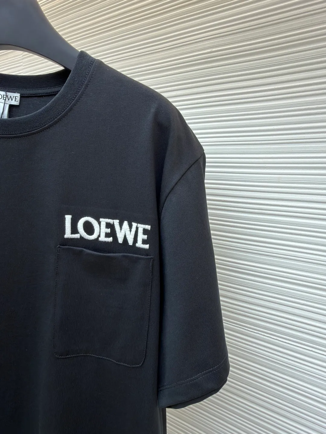 Loewe Patch Pocket Round Neck Short Sleeve ●Original version: Purchased and developed by 3621 ●Item number: 1681853-A00 ●Material: combed cotton fabric ●Technology: embroidery production ●Color: black ●Version: fitted version ●Weight: about 265 grams ●Size: XS-S-M-L ●Description: Made of 15S fine cotton plain fabric, 230g; with 32S double yarn thread, 300g. Plain weave fabric made from combed cotton fibers has a more orderly arrangement and higher density than ordinary cotton, so it has better texture and luster. 15S fine cotton plain fabric is a high-quality cotton fabric with the characteristics of softness, comfort, good breathability, and good durability. Matching the specific color and thick thread material, single-needle lock embroidery is mainly used, and the stitches of this embroidery are fine. The craftsmanship is exquisite. The edge of the pattern not only makes the embroidery appear smooth, but also the stitches are arranged neatly and evenly, without exposing the ground or overlapping. The embroidery uses thick lines to outline the letter pattern, and the thick lines create a more three-dimensional texture. Thick thread embroidery has the rough feel of hand embroidery, and the overall effect is three-dimensional and the texture is delicate, creating a dual texture in terms of look and feel. The overall wiring is straight and delicate, the fabric is comfortable and soft, and the color is consistent without color difference. It can be matched with the same style to create a fashionable look and control various occasions. Customized accessories, complete with three standards, same style for men and women!