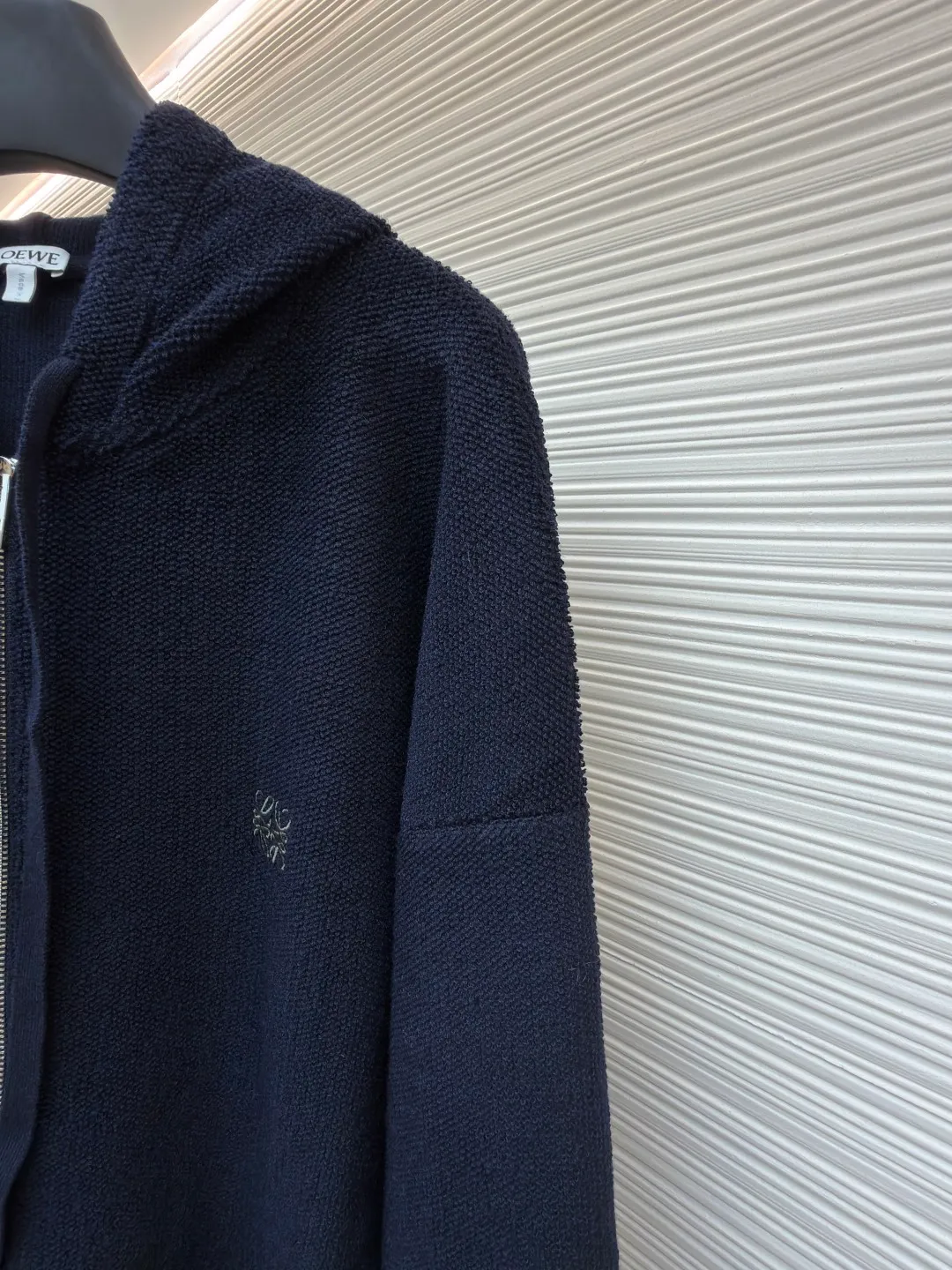 Loewe embroidered hooded zipper cardigan ●Original version: Purchased and developed by 10204 ●Item number: 1682195-B70 ●Material: wool blended fabric ●Technology: embroidery production ●Color: navy ●Version: Loose fit ●Weight: about 950 grams ●Size: S-M-L-XL ●Description: Selected high-quality wool as the main body, with unique terry cloth stitching technology, is a highlight of this sweatshirt. This stitching method not only gives the sweatshirt a unique texture and texture, but also demonstrates our stringent quality requirements in every detail. Every seam is tight and even, like a carefully carved work of art, which not only enhances the durability of the clothing, but also adds a unique fashion charm. Ribbed cuffs and hem are the perfect combination of classic and practical. They fit the body well, prevent cold wind from getting in, and provide excellent warmth. At the same time, the elastic properties of the ribs also ensure the comfort of wearing it and will not cause any restrictions on body movements. On the chest, the high-precision calculation system of the computer embroidery machine controls the coordinated operation of the machine head, needle bar, and thread spool. The fabric frame moves accurately in the horizontal and vertical directions to form a stitch track. The upper and lower thread tensions are adjusted to ensure that the stitches are smooth and free of floating threads, forming anagram embroidery with an error of ±0.1mm. The overall wiring is straight and delicate, the fabric is comfortable and soft, and the color is consistent without color difference. It can be matched with the same style to create a fashionable look and control various occasions. Customized accessories, complete with three standards, same style for men and women!