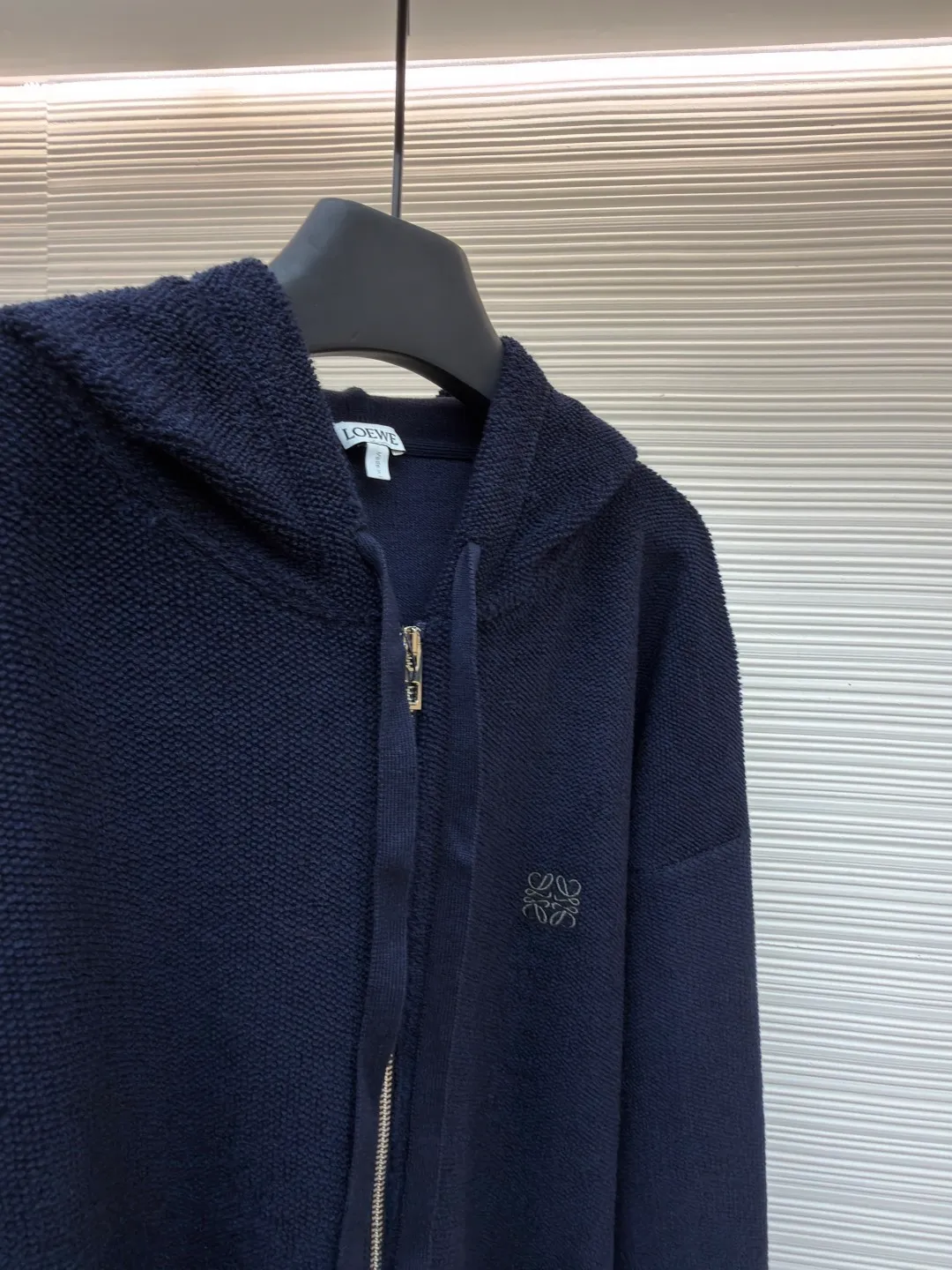Loewe embroidered hooded zipper cardigan ●Original version: Purchased and developed by 10204 ●Item number: 1682195-B70 ●Material: wool blended fabric ●Technology: embroidery production ●Color: navy ●Version: Loose fit ●Weight: about 950 grams ●Size: S-M-L-XL ●Description: Selected high-quality wool as the main body, with unique terry cloth stitching technology, is a highlight of this sweatshirt. This stitching method not only gives the sweatshirt a unique texture and texture, but also demonstrates our stringent quality requirements in every detail. Every seam is tight and even, like a carefully carved work of art, which not only enhances the durability of the clothing, but also adds a unique fashion charm. Ribbed cuffs and hem are the perfect combination of classic and practical. They fit the body well, prevent cold wind from getting in, and provide excellent warmth. At the same time, the elastic properties of the ribs also ensure the comfort of wearing it and will not cause any restrictions on body movements. On the chest, the high-precision calculation system of the computer embroidery machine controls the coordinated operation of the machine head, needle bar, and thread spool. The fabric frame moves accurately in the horizontal and vertical directions to form a stitch track. The upper and lower thread tensions are adjusted to ensure that the stitches are smooth and free of floating threads, forming anagram embroidery with an error of ±0.1mm. The overall wiring is straight and delicate, the fabric is comfortable and soft, and the color is consistent without color difference. It can be matched with the same style to create a fashionable look and control various occasions. Customized accessories, complete with three standards, same style for men and women!