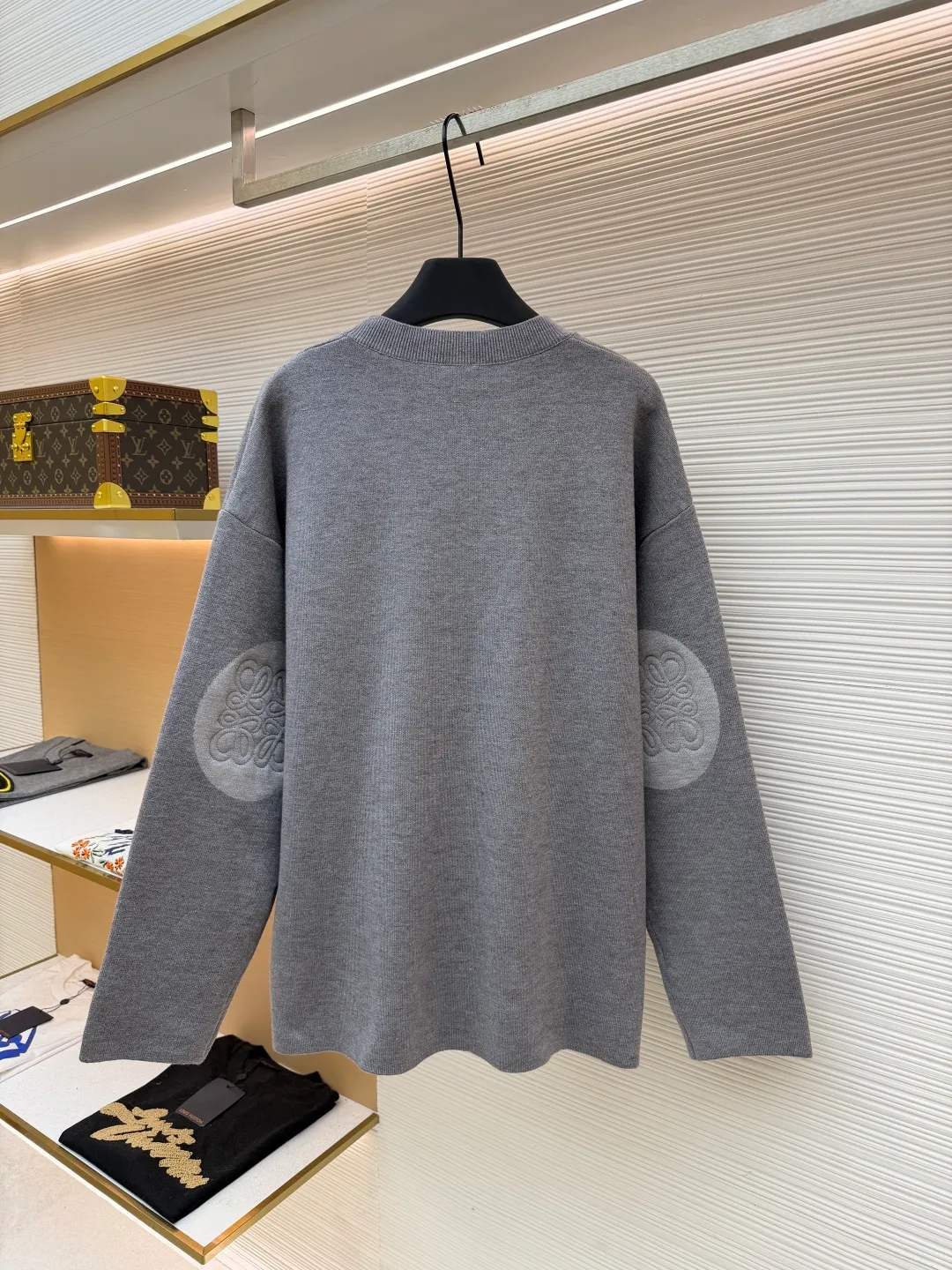 Loewe padded 3D embroidered crew neck sweater ●Original version: purchased and developed by 10958 ●Item number: 1681874-A85 ●Fabric: wool blended fabric ●Technology: 3D embroidery production ●Color: gray ●Version: fitted version ●Weight: about 555 grams ●Size: S-M-L-XL ●Description: Made of wool blended fabric, mainly 96% wool, combined with 3% nylon and 1% spandex. The main body of wool ensures the warmth and comfort of the clothing. The addition of a small amount of nylon and spandex significantly improves the elasticity and wear resistance. The ribbed decorative parts are made of 100% wool, which further enhances the texture and wearing experience. Tightly fasten the fabric and cushioning material to the frame of the embroidery machine. The embroidery machine uses sparse stitches along the pattern of the cushion layer to outline the filling area of the pattern. Then it runs the pattern of the overlay layer, using dense stitches to perfectly cover the foam cushion layer, thus forming a slightly raised Anagram embroidery, which is soft and soft to the touch. The full and thick thread layer plays a protective role and greatly improves its wear resistance. Add detergent and preliminarily rinse the bulk goods at a water temperature of about 35 degrees to remove impurities during the production process. The protease is then used to gently digest the hairiness on the surface, thereby reducing the tendency to pilling from the source, improving the feel, retaining softness, and eliminating irritation. Finally, after dehydration and drying, the dimensional and shape stability is improved. The overall wiring is straight and delicate, the fabric is comfortable and soft, and the color is consistent without color difference. It can be matched with the same style to create a fashionable look and control various occasions. Customized accessories, complete with three standards, same style for men and women!