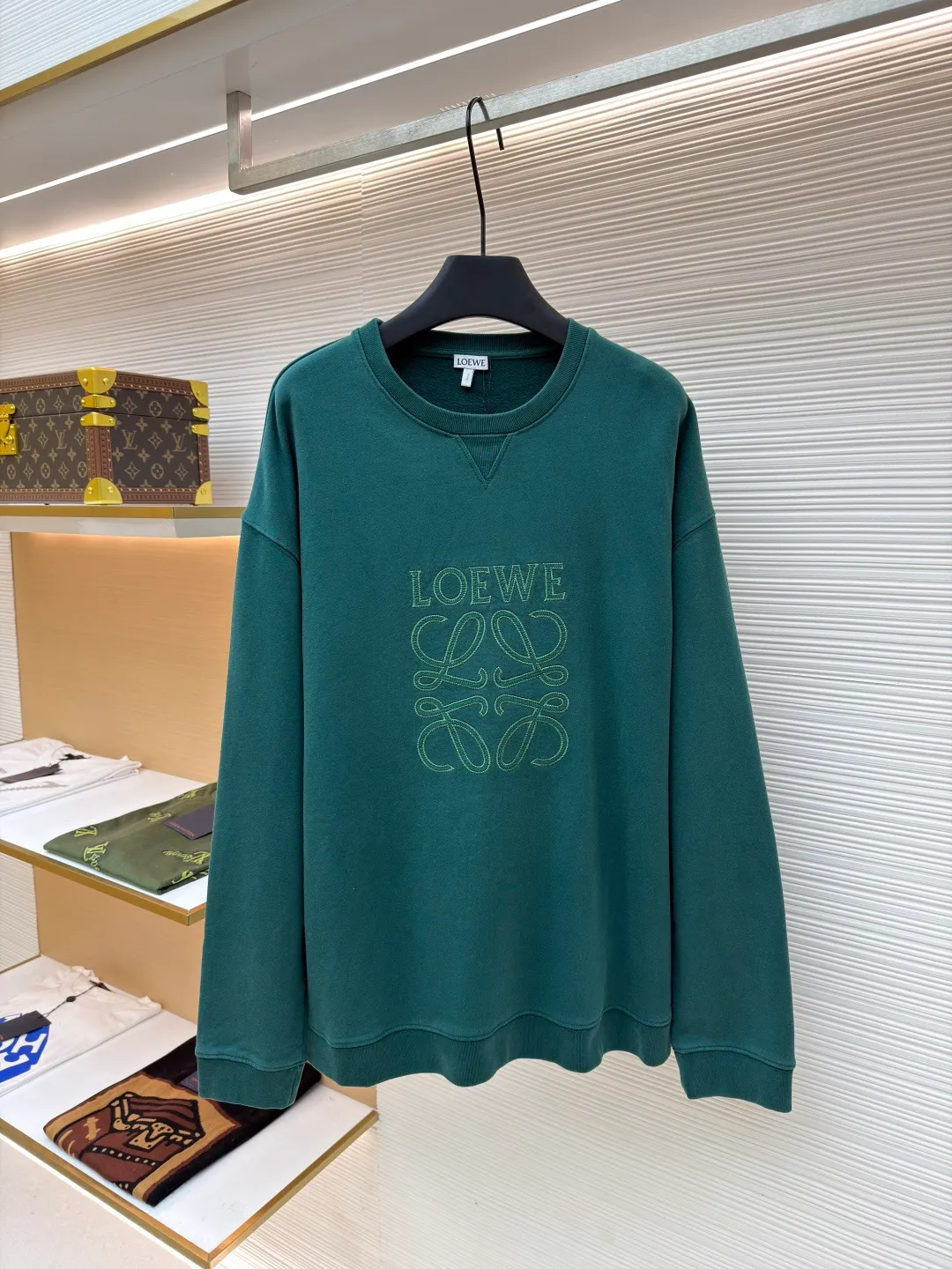 Loewe zigzag thread appliqué round neck sweatshirt ●Original version: Purchased and developed by 3621 ●Item number: 1680967-A90 ●Fabric: Fleece fabric ●Technology: Laser cutting appliqué production ●Version: Fitted version ●Weight: about 635g ●Size: 2*2 thread, 470g. The fish scale bottom fabric forms a fish scale pattern through a specific weaving process, and the plates are arranged and interwoven according to the warp and weft patterns and shapes to ensure clear texture and excellent texture. The fabric has been carefully produced and processed, and has good durability, lightness, softness, and good breathability. The edge-strengthened branches of the appliqué embroidery add a rough industrial look by imitating zigzag-shaped stitches. The appliqué stitches are in the form of trapezoidal zigzags, resembling interlaced canine teeth; emphasizing high stitch density and sharp turns, like saw blade cutting marks. Trim the seam allowance and cut off excess fabric along the dogtooth stitches to retain the jagged three-dimensional effect. After the garment is made, it is made through frying process. The garment is dyed, washed and aged using new environmentally friendly technology. Fabrics are dyed using a stone grinding method, and the garments are continuously immersed in dye and tumbled. After frying the sand, the fabric fades slightly, changing the color of the original fabric to show a nostalgic color with different shades of light and dark. The neckline adopts a structural feature formed by a V-shaped rib weaving method, which visually has a unique sense of line and extensibility. The rib structure itself has good elasticity and stretchability; inserts are added to the shoulder seams to increase the service life. The neckline, hem, and cuffs are all spliced ​​with double-needle threading. The body and sleeves are structurally split and quilted. The fabric material has high ductility and no sense of restraint. The overall wiring is straight and delicate, the fabric is comfortable and soft, and the color is consistent without color difference. It can be matched with the same style to create a fashionable look and control various occasions. Customized accessories, complete with three standards, same style for men and women!