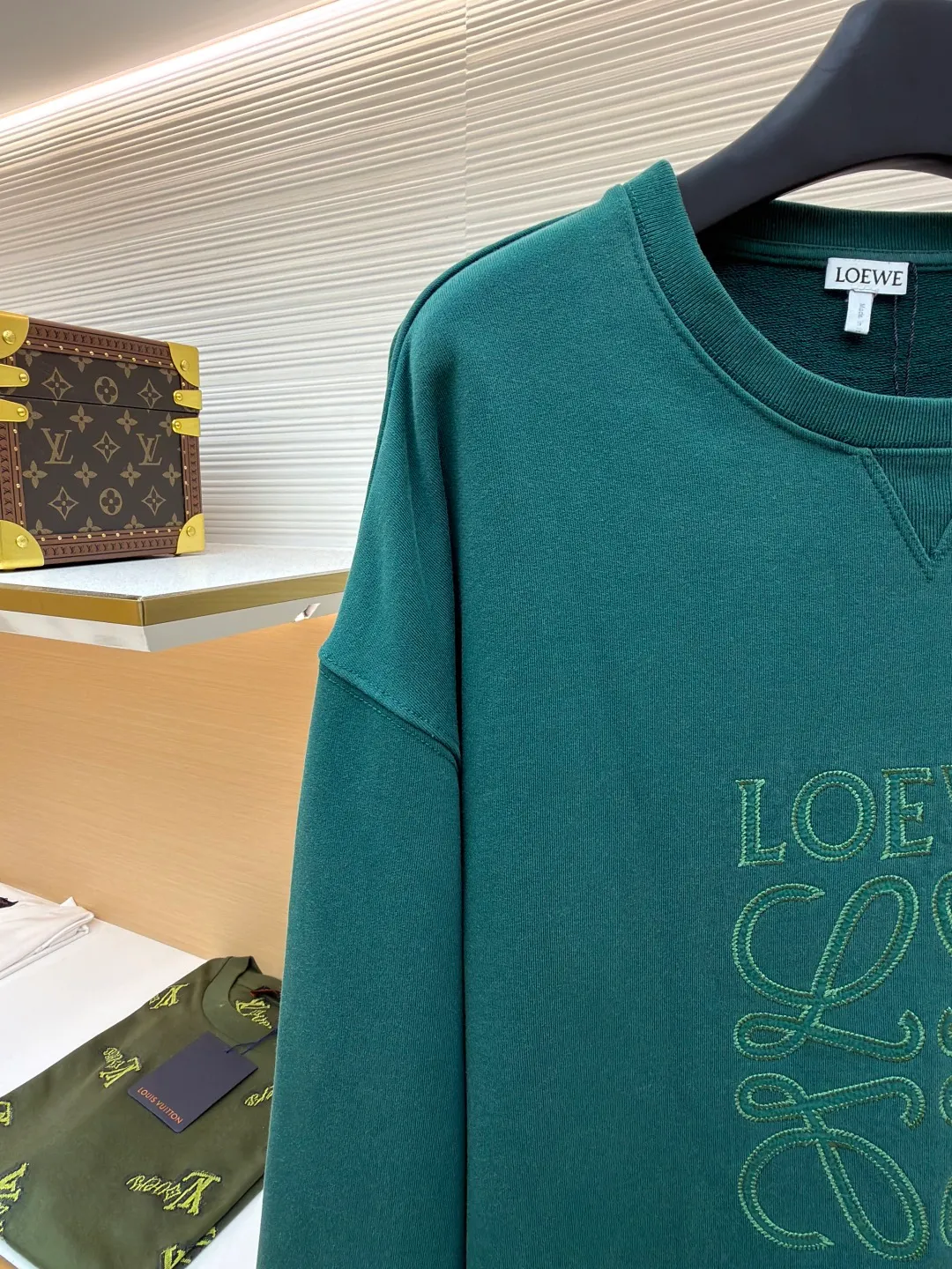Loewe zigzag thread appliqué round neck sweatshirt ●Original version: Purchased and developed by 3621 ●Item number: 1680967-A90 ●Fabric: Fleece fabric ●Technology: Laser cutting appliqué production ●Version: Fitted version ●Weight: about 635g ●Size: 2*2 thread, 470g. The fish scale bottom fabric forms a fish scale pattern through a specific weaving process, and the plates are arranged and interwoven according to the warp and weft patterns and shapes to ensure clear texture and excellent texture. The fabric has been carefully produced and processed, and has good durability, lightness, softness, and good breathability. The edge-strengthened branches of the appliqué embroidery add a rough industrial look by imitating zigzag-shaped stitches. The appliqué stitches are in the form of trapezoidal zigzags, resembling interlaced canine teeth; emphasizing high stitch density and sharp turns, like saw blade cutting marks. Trim the seam allowance and cut off excess fabric along the dogtooth stitches to retain the jagged three-dimensional effect. After the garment is made, it is made through frying process. The garment is dyed, washed and aged using new environmentally friendly technology. Fabrics are dyed using a stone grinding method, and the garments are continuously immersed in dye and tumbled. After frying the sand, the fabric fades slightly, changing the color of the original fabric to show a nostalgic color with different shades of light and dark. The neckline adopts a structural feature formed by a V-shaped rib weaving method, which visually has a unique sense of line and extensibility. The rib structure itself has good elasticity and stretchability; inserts are added to the shoulder seams to increase the service life. The neckline, hem, and cuffs are all spliced ​​with double-needle threading. The body and sleeves are structurally split and quilted. The fabric material has high ductility and no sense of restraint. The overall wiring is straight and delicate, the fabric is comfortable and soft, and the color is consistent without color difference. It can be matched with the same style to create a fashionable look and control various occasions. Customized accessories, complete with three standards, same style for men and women!