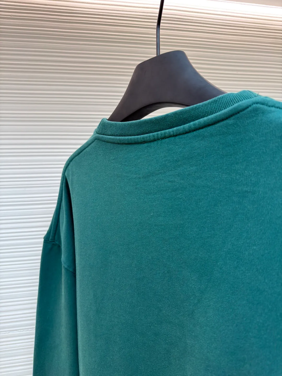 Loewe zigzag thread appliqué round neck sweatshirt ●Original version: Purchased and developed by 3621 ●Item number: 1680967-A90 ●Fabric: Fleece fabric ●Technology: Laser cutting appliqué production ●Version: Fitted version ●Weight: about 635g ●Size: 2*2 thread, 470g. The fish scale bottom fabric forms a fish scale pattern through a specific weaving process, and the plates are arranged and interwoven according to the warp and weft patterns and shapes to ensure clear texture and excellent texture. The fabric has been carefully produced and processed, and has good durability, lightness, softness, and good breathability. The edge-strengthened branches of the appliqué embroidery add a rough industrial look by imitating zigzag-shaped stitches. The appliqué stitches are in the form of trapezoidal zigzags, resembling interlaced canine teeth; emphasizing high stitch density and sharp turns, like saw blade cutting marks. Trim the seam allowance and cut off excess fabric along the dogtooth stitches to retain the jagged three-dimensional effect. After the garment is made, it is made through frying process. The garment is dyed, washed and aged using new environmentally friendly technology. Fabrics are dyed using a stone grinding method, and the garments are continuously immersed in dye and tumbled. After frying the sand, the fabric fades slightly, changing the color of the original fabric to show a nostalgic color with different shades of light and dark. The neckline adopts a structural feature formed by a V-shaped rib weaving method, which visually has a unique sense of line and extensibility. The rib structure itself has good elasticity and stretchability; inserts are added to the shoulder seams to increase the service life. The neckline, hem, and cuffs are all spliced ​​with double-needle threading. The body and sleeves are structurally split and quilted. The fabric material has high ductility and no sense of restraint. The overall wiring is straight and delicate, the fabric is comfortable and soft, and the color is consistent without color difference. It can be matched with the same style to create a fashionable look and control various occasions. Customized accessories, complete with three standards, same style for men and women!