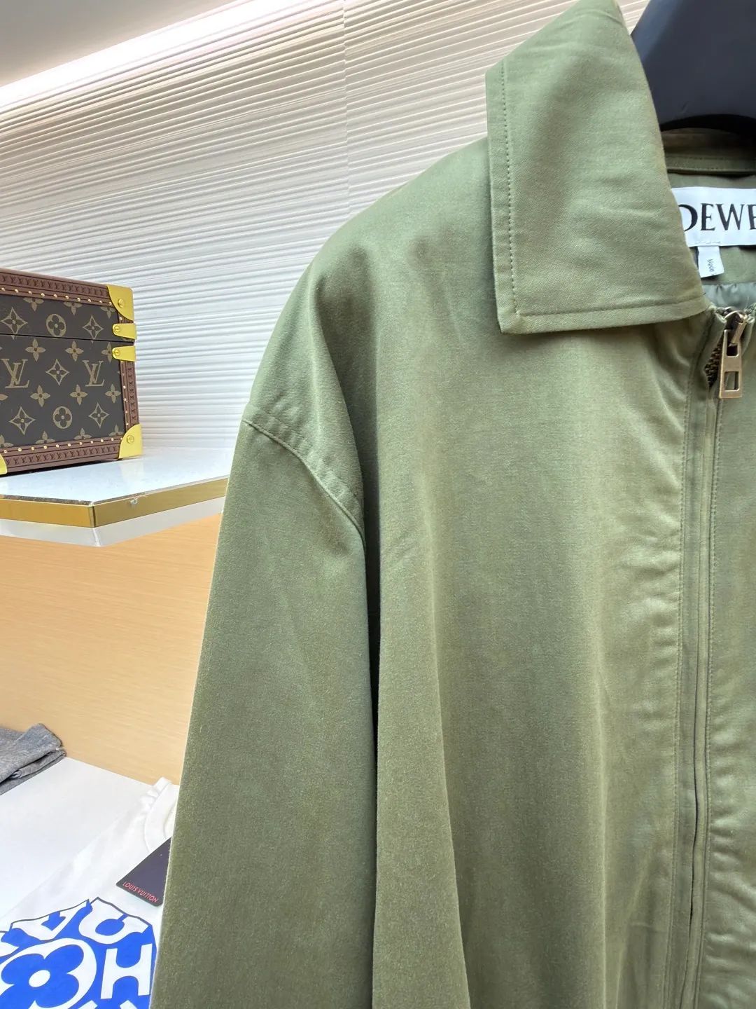 Loewe Army Green Trimmed Jacket ●Original version: Purchased and developed for 20900 ●Item number: 1682098-B40 ●Fabric: High weight dyed cotton satin fabric ●Technology: Leather patch production ●Color: Military green ●Version: Fitted version ●Weight: about 745 grams ●Size: 46-48-50-52 ●Description: Made of 100% pure cotton cloth, the fabric is dyed in the original color. The leather label is made of real cowhide composite, and the surface is stamped with gold powder to create the brand logo. The waist belt is made of multi-layer composite, and the oil edge design presents a different visual effect. Medium weight garment-dyed cotton satin jacket with gathered front and decorative contrasting belt. * Regular fit, standard length * Classic collar * Front zip closure, button cuffs * Seamed pockets, internal welt pockets * Fully lined * Anagram embroidery on chest, LOEWE embossed leather patch on back. The overall wiring is straight and delicate, the fabric is comfortable and soft, and the color is consistent without color difference. It can be matched with the same style to create a fashionable look and control various occasions. Customized accessories, complete with three standards, same style for men and women!