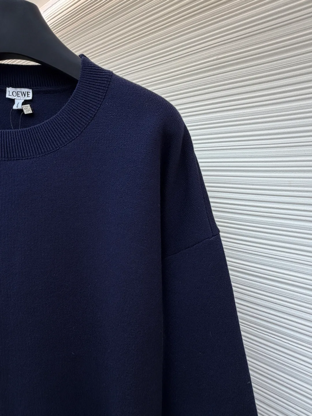 Loewe padded 3D embroidered crew neck sweater ●Original version: purchased and developed by 15168 ●Item number: 1681872-A85 ●Fabric: wool blended fabric ●Technology: 3D embroidery production ●Color: navy blue ●Version: fitted version ●Weight: about 565 grams ●Size: S-M-L-XL ●Description: Made of wool blended fabric, mainly 96% wool, combined with 3% nylon and 1% spandex. The main body of wool ensures the warmth and comfort of the clothing. The addition of a small amount of nylon and spandex significantly improves the elasticity and wear resistance. The ribbed decorative parts are made of 100% wool, which further enhances the texture and wearing experience. Tightly fasten the fabric and cushioning material to the frame of the embroidery machine. The embroidery machine uses sparse stitches along the pattern of the cushion layer to outline the filling area of the pattern. Then it runs the pattern of the overlay layer, using dense stitches to perfectly cover the foam cushion layer, thus forming a slightly raised Anagram embroidery, which is soft and soft to the touch. The full and thick thread layer plays a protective role and greatly improves its wear resistance. Add detergent and preliminarily rinse the bulk goods at a water temperature of about 35 degrees to remove impurities during the production process. The protease is then used to gently digest the hairiness on the surface, thereby reducing the tendency to pilling from the source, improving the feel, retaining softness, and eliminating irritation. Finally, after dehydration and drying, the dimensional and shape stability is improved. The overall wiring is straight and delicate, the fabric is comfortable and soft, and the color is consistent without color difference. It can be matched with the same style to create a fashionable look and control various occasions. Customized accessories, complete with three standards, same style for men and women!