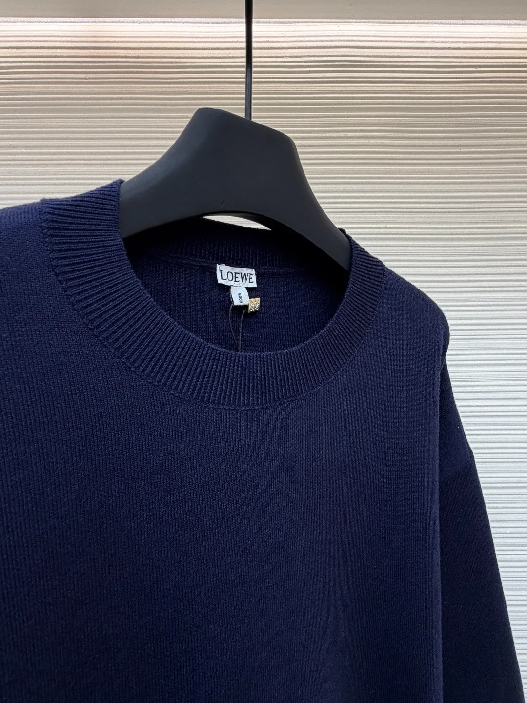 Loewe padded 3D embroidered crew neck sweater ●Original version: purchased and developed by 15168 ●Item number: 1681872-A85 ●Fabric: wool blended fabric ●Technology: 3D embroidery production ●Color: navy blue ●Version: fitted version ●Weight: about 565 grams ●Size: S-M-L-XL ●Description: Made of wool blended fabric, mainly 96% wool, combined with 3% nylon and 1% spandex. The main body of wool ensures the warmth and comfort of the clothing. The addition of a small amount of nylon and spandex significantly improves the elasticity and wear resistance. The ribbed decorative parts are made of 100% wool, which further enhances the texture and wearing experience. Tightly fasten the fabric and cushioning material to the frame of the embroidery machine. The embroidery machine uses sparse stitches along the pattern of the cushion layer to outline the filling area of the pattern. Then it runs the pattern of the overlay layer, using dense stitches to perfectly cover the foam cushion layer, thus forming a slightly raised Anagram embroidery, which is soft and soft to the touch. The full and thick thread layer plays a protective role and greatly improves its wear resistance. Add detergent and preliminarily rinse the bulk goods at a water temperature of about 35 degrees to remove impurities during the production process. The protease is then used to gently digest the hairiness on the surface, thereby reducing the tendency to pilling from the source, improving the feel, retaining softness, and eliminating irritation. Finally, after dehydration and drying, the dimensional and shape stability is improved. The overall wiring is straight and delicate, the fabric is comfortable and soft, and the color is consistent without color difference. It can be matched with the same style to create a fashionable look and control various occasions. Customized accessories, complete with three standards, same style for men and women!