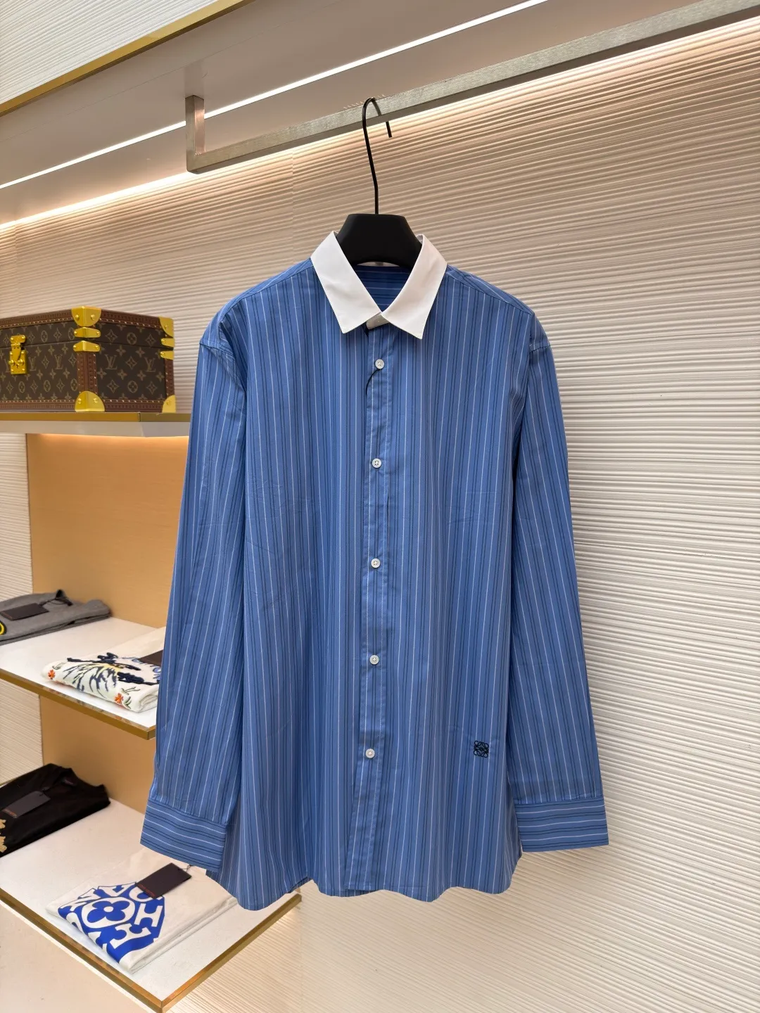 Loewe color-blocked striped single-breasted pointed collar long-sleeved shirt ●Original version: Purchased and developed for 4799 ●Item number: 1682522-A70 ●Material: cotton gingham fabric ●Technology: made on positioning cutting machine ●Color: blue ●Version: fitted version ●Weight: about 210 grams ●Size: 37-38-39-40 ●Description: This LOEWE blue and white striped shirt is made of high-count pure cotton poplin fabric. After pre-washing process, it feels smooth and breathable. It has good stiffness and drape, and is not easy to wrinkle and deform. The stripes on the body are woven using yarn-dyed technology. The blue and white color scheme is classic and the texture is clear. It will not fade or color bleed after repeated washing. The shirt adopts a contrasting fake two-layer collar design. The white small lapels form a layered contrast with the blue body. The custom-made mother-of-pearl buttons at the placket have a warm texture. The cuffs are designed with classic sleeves. The brand embroidered logo at the hem is densely stitched to highlight the brand recognition. The overall cut is a loose fit, the shoulder joints are straight and fine, the customized accessories and three standards are complete, and the detailed craftsmanship shows the level of luxury. It is suitable for various wearing scenarios such as daily commuting and light business. The overall wiring is straight and delicate, the fabric is comfortable and soft, and the color is consistent without color difference. It can be matched with the same style to create a fashionable look and control various occasions. Customized accessories, complete with three standards, same style for men and women!