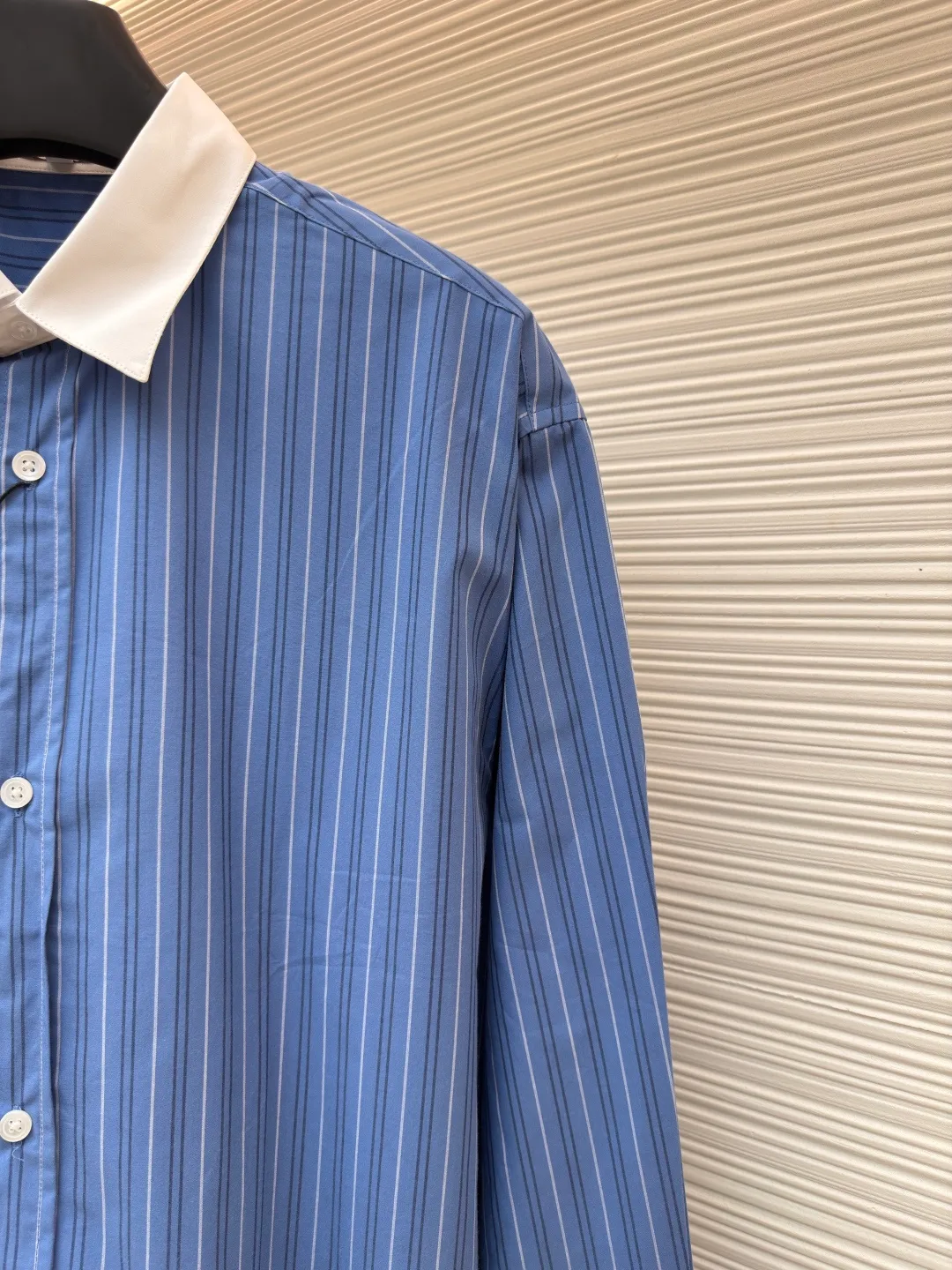 Loewe color-blocked striped single-breasted pointed collar long-sleeved shirt ●Original version: Purchased and developed for 4799 ●Item number: 1682522-A70 ●Material: cotton gingham fabric ●Technology: made on positioning cutting machine ●Color: blue ●Version: fitted version ●Weight: about 210 grams ●Size: 37-38-39-40 ●Description: This LOEWE blue and white striped shirt is made of high-count pure cotton poplin fabric. After pre-washing process, it feels smooth and breathable. It has good stiffness and drape, and is not easy to wrinkle and deform. The stripes on the body are woven using yarn-dyed technology. The blue and white color scheme is classic and the texture is clear. It will not fade or color bleed after repeated washing. The shirt adopts a contrasting fake two-layer collar design. The white small lapels form a layered contrast with the blue body. The custom-made mother-of-pearl buttons at the placket have a warm texture. The cuffs are designed with classic sleeves. The brand embroidered logo at the hem is densely stitched to highlight the brand recognition. The overall cut is a loose fit, the shoulder joints are straight and fine, the customized accessories and three standards are complete, and the detailed craftsmanship shows the level of luxury. It is suitable for various wearing scenarios such as daily commuting and light business. The overall wiring is straight and delicate, the fabric is comfortable and soft, and the color is consistent without color difference. It can be matched with the same style to create a fashionable look and control various occasions. Customized accessories, complete with three standards, same style for men and women!