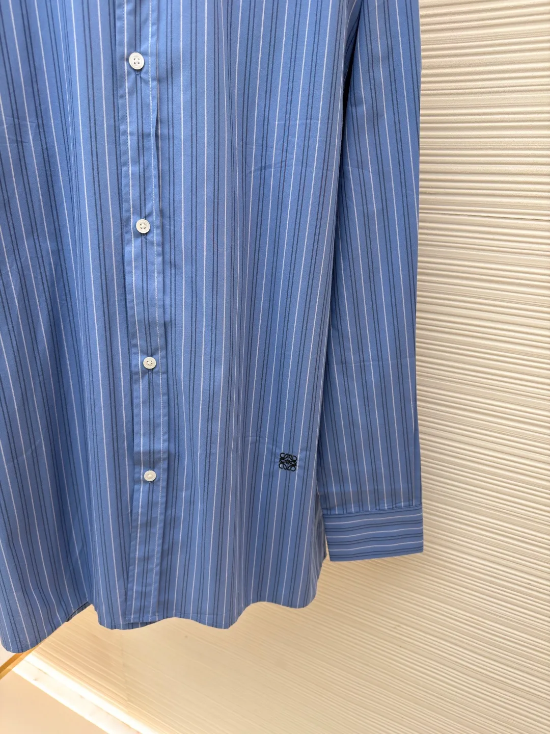 Loewe color-blocked striped single-breasted pointed collar long-sleeved shirt ●Original version: Purchased and developed for 4799 ●Item number: 1682522-A70 ●Material: cotton gingham fabric ●Technology: made on positioning cutting machine ●Color: blue ●Version: fitted version ●Weight: about 210 grams ●Size: 37-38-39-40 ●Description: This LOEWE blue and white striped shirt is made of high-count pure cotton poplin fabric. After pre-washing process, it feels smooth and breathable. It has good stiffness and drape, and is not easy to wrinkle and deform. The stripes on the body are woven using yarn-dyed technology. The blue and white color scheme is classic and the texture is clear. It will not fade or color bleed after repeated washing. The shirt adopts a contrasting fake two-layer collar design. The white small lapels form a layered contrast with the blue body. The custom-made mother-of-pearl buttons at the placket have a warm texture. The cuffs are designed with classic sleeves. The brand embroidered logo at the hem is densely stitched to highlight the brand recognition. The overall cut is a loose fit, the shoulder joints are straight and fine, the customized accessories and three standards are complete, and the detailed craftsmanship shows the level of luxury. It is suitable for various wearing scenarios such as daily commuting and light business. The overall wiring is straight and delicate, the fabric is comfortable and soft, and the color is consistent without color difference. It can be matched with the same style to create a fashionable look and control various occasions. Customized accessories, complete with three standards, same style for men and women!