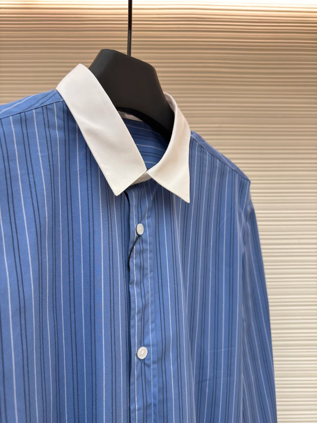 Loewe color-blocked striped single-breasted pointed collar long-sleeved shirt ●Original version: Purchased and developed for 4799 ●Item number: 1682522-A70 ●Material: cotton gingham fabric ●Technology: made on positioning cutting machine ●Color: blue ●Version: fitted version ●Weight: about 210 grams ●Size: 37-38-39-40 ●Description: This LOEWE blue and white striped shirt is made of high-count pure cotton poplin fabric. After pre-washing process, it feels smooth and breathable. It has good stiffness and drape, and is not easy to wrinkle and deform. The stripes on the body are woven using yarn-dyed technology. The blue and white color scheme is classic and the texture is clear. It will not fade or color bleed after repeated washing. The shirt adopts a contrasting fake two-layer collar design. The white small lapels form a layered contrast with the blue body. The custom-made mother-of-pearl buttons at the placket have a warm texture. The cuffs are designed with classic sleeves. The brand embroidered logo at the hem is densely stitched to highlight the brand recognition. The overall cut is a loose fit, the shoulder joints are straight and fine, the customized accessories and three standards are complete, and the detailed craftsmanship shows the level of luxury. It is suitable for various wearing scenarios such as daily commuting and light business. The overall wiring is straight and delicate, the fabric is comfortable and soft, and the color is consistent without color difference. It can be matched with the same style to create a fashionable look and control various occasions. Customized accessories, complete with three standards, same style for men and women!