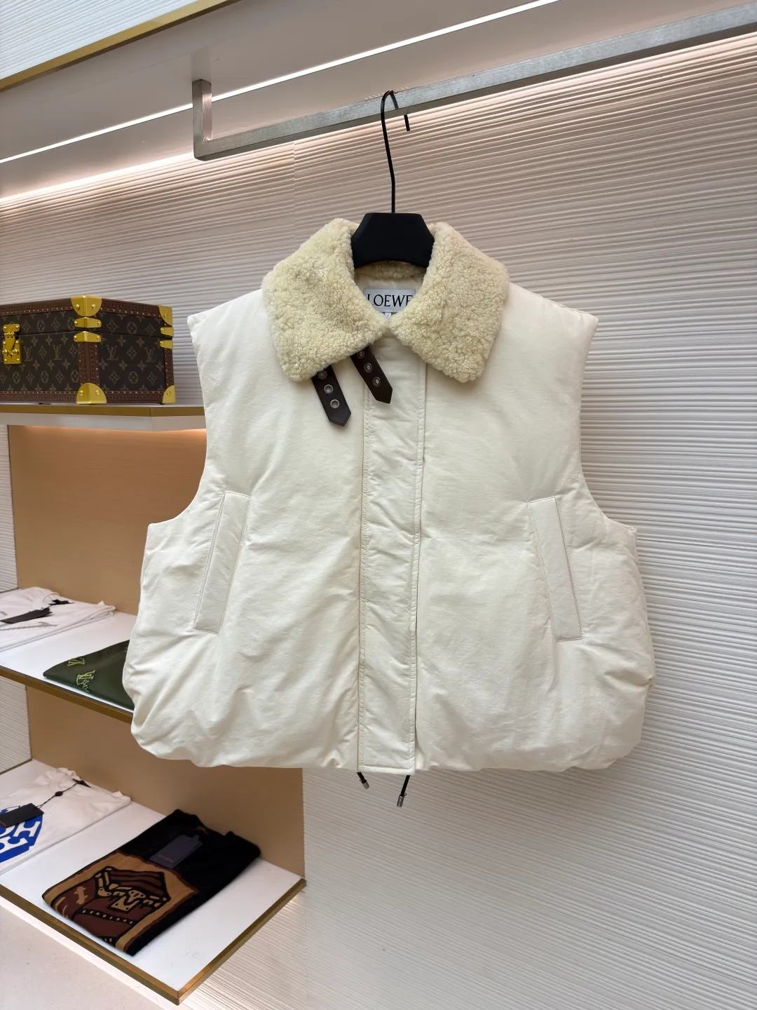 LOEWE lamb collar stitching tie decorative vest ●Original version: Purchased and developed in 20277 ●Item number: 1680964-E65 ●Fabric: Sheepskin lamb fabric ●Technology: embroidery production ●Version: Fitted version ●Weight: about 1005 grams ●Size: S-M-L ●Description: Made of Oxford fabric blended with 60% cotton and 40% nylon. Cotton fiber has a natural skin-friendly feel and good moisture absorption and breathability. The addition of nylon improves wear resistance and skeleton strength, while the high-density braid layer enhances the velvet locking effect. The lambswool lapel design effectively wraps the neck and reduces heat loss. Its texture is soft, delicate to the touch, close to the skin and non-irritating, providing a comfortable experience. The furry texture can modify facial lines, making the face look smaller and more refined. It uses 90 white duck down with a weight of 220g to ensure excellent thermal insulation performance. After strict screening and processing, the velvet is not easy to get drilled, ensuring durability. The inner and outer denim fabrics are misaligned by 1.5 cm, blocking the migration path of velvet. The anti-velvet silk thread is used through the imported No. 7 needle to achieve a chain stitch of 14 stitches/inch, resulting in tight and straight stitch spacing and a sewing effect without skipping stitches. The inner bag surface is formed into high-precision Anagram embroidery with about 6,000 stitches through the advanced computer control system and precision mechanical components of the imported embroidery machine. The overall wiring is straight and delicate, the fabric is comfortable and soft, and the color is consistent without color difference. It can be matched with the same style to create a fashionable look and control various occasions. Customized accessories, complete with three standards, same style for men and women!