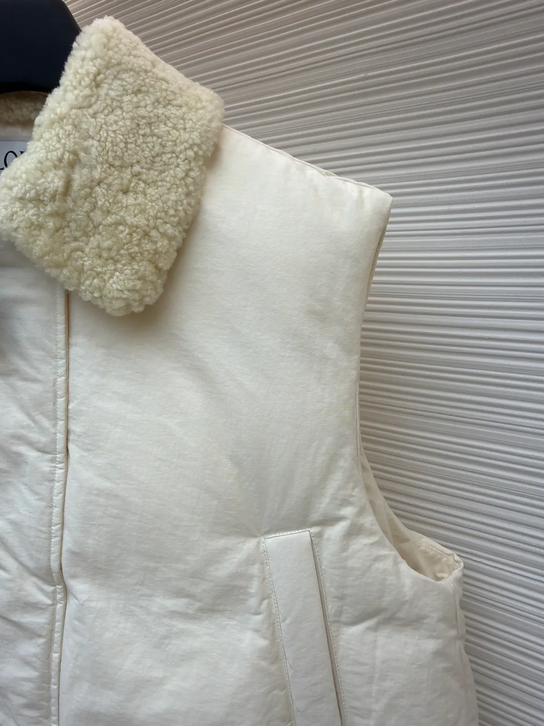 LOEWE lamb collar stitching tie decorative vest ●Original version: Purchased and developed in 20277 ●Item number: 1680964-E65 ●Fabric: Sheepskin lamb fabric ●Technology: embroidery production ●Version: Fitted version ●Weight: about 1005 grams ●Size: S-M-L ●Description: Made of Oxford fabric blended with 60% cotton and 40% nylon. Cotton fiber has a natural skin-friendly feel and good moisture absorption and breathability. The addition of nylon improves wear resistance and skeleton strength, while the high-density braid layer enhances the velvet locking effect. The lambswool lapel design effectively wraps the neck and reduces heat loss. Its texture is soft, delicate to the touch, close to the skin and non-irritating, providing a comfortable experience. The furry texture can modify facial lines, making the face look smaller and more refined. It uses 90 white duck down with a weight of 220g to ensure excellent thermal insulation performance. After strict screening and processing, the velvet is not easy to get drilled, ensuring durability. The inner and outer denim fabrics are misaligned by 1.5 cm, blocking the migration path of velvet. The anti-velvet silk thread is used through the imported No. 7 needle to achieve a chain stitch of 14 stitches/inch, resulting in tight and straight stitch spacing and a sewing effect without skipping stitches. The inner bag surface is formed into high-precision Anagram embroidery with about 6,000 stitches through the advanced computer control system and precision mechanical components of the imported embroidery machine. The overall wiring is straight and delicate, the fabric is comfortable and soft, and the color is consistent without color difference. It can be matched with the same style to create a fashionable look and control various occasions. Customized accessories, complete with three standards, same style for men and women!